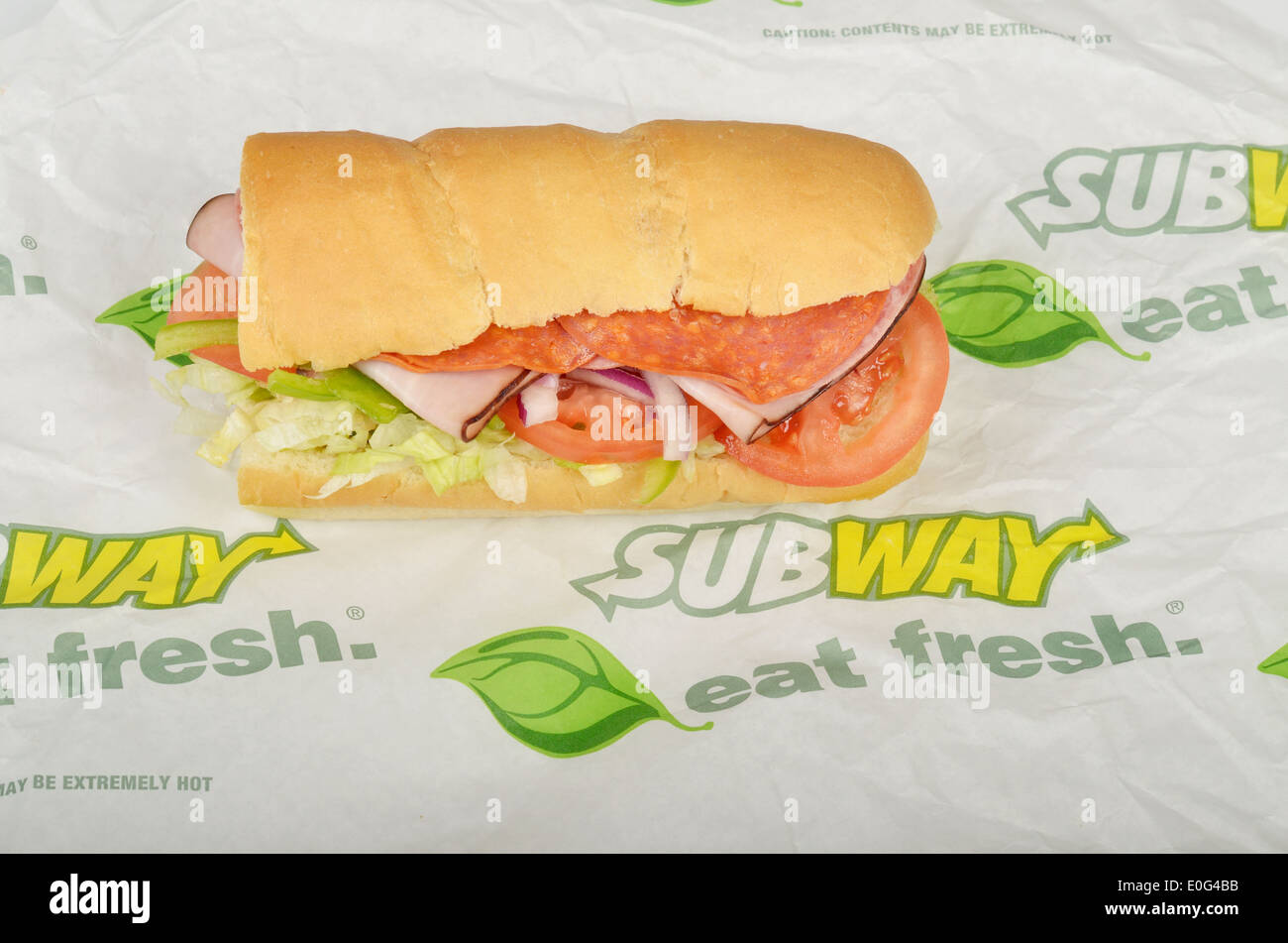 Metro BMT sub sándwich en pan italiano rollo con Génova, salami, jamón Black Forest, guindilla. lechuga, tomate y cebolla en la envoltura de papel. Ee.Uu. Foto de stock