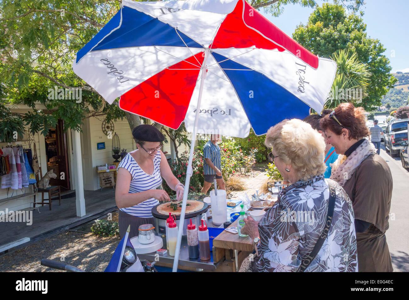 Akaroa Nueva Zelanda - Les Crêpes d'Elise haciendo panqueques crepes francesas de venta a los pasajeros de los cruceros de una cesta de alimentos en la tienda francesa La Folie Jolie Foto de stock