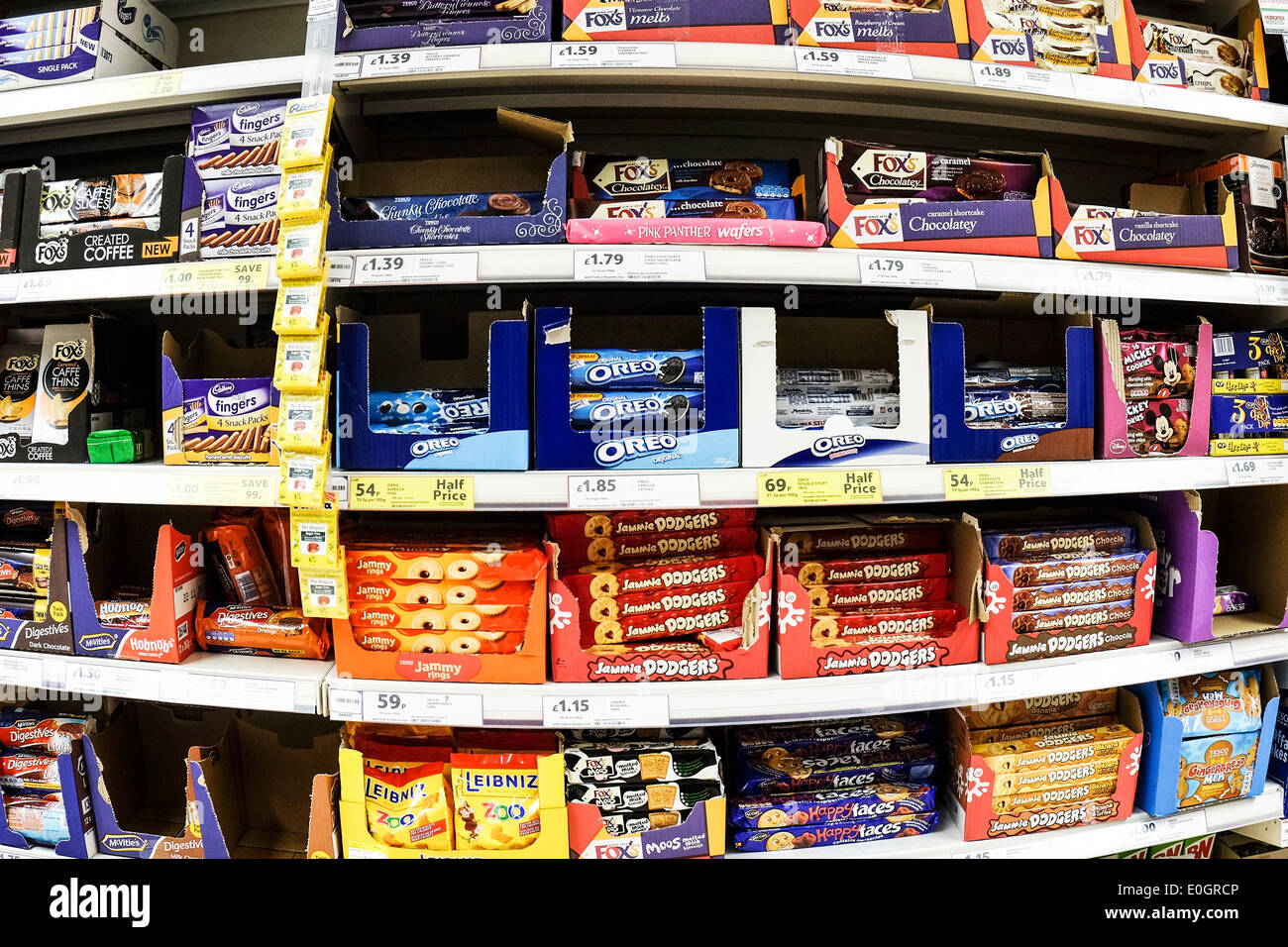 Estantes de paquetes de galletas en la pantalla en un supermercado Tesco. Foto de stock
