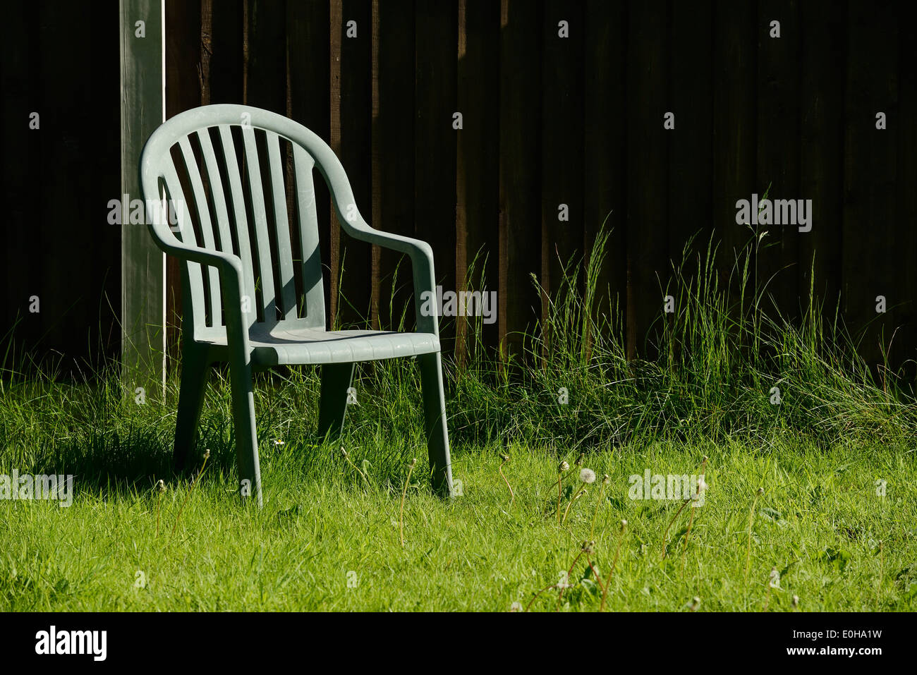 Solitaria silla de jardín de plástico verde Foto de stock