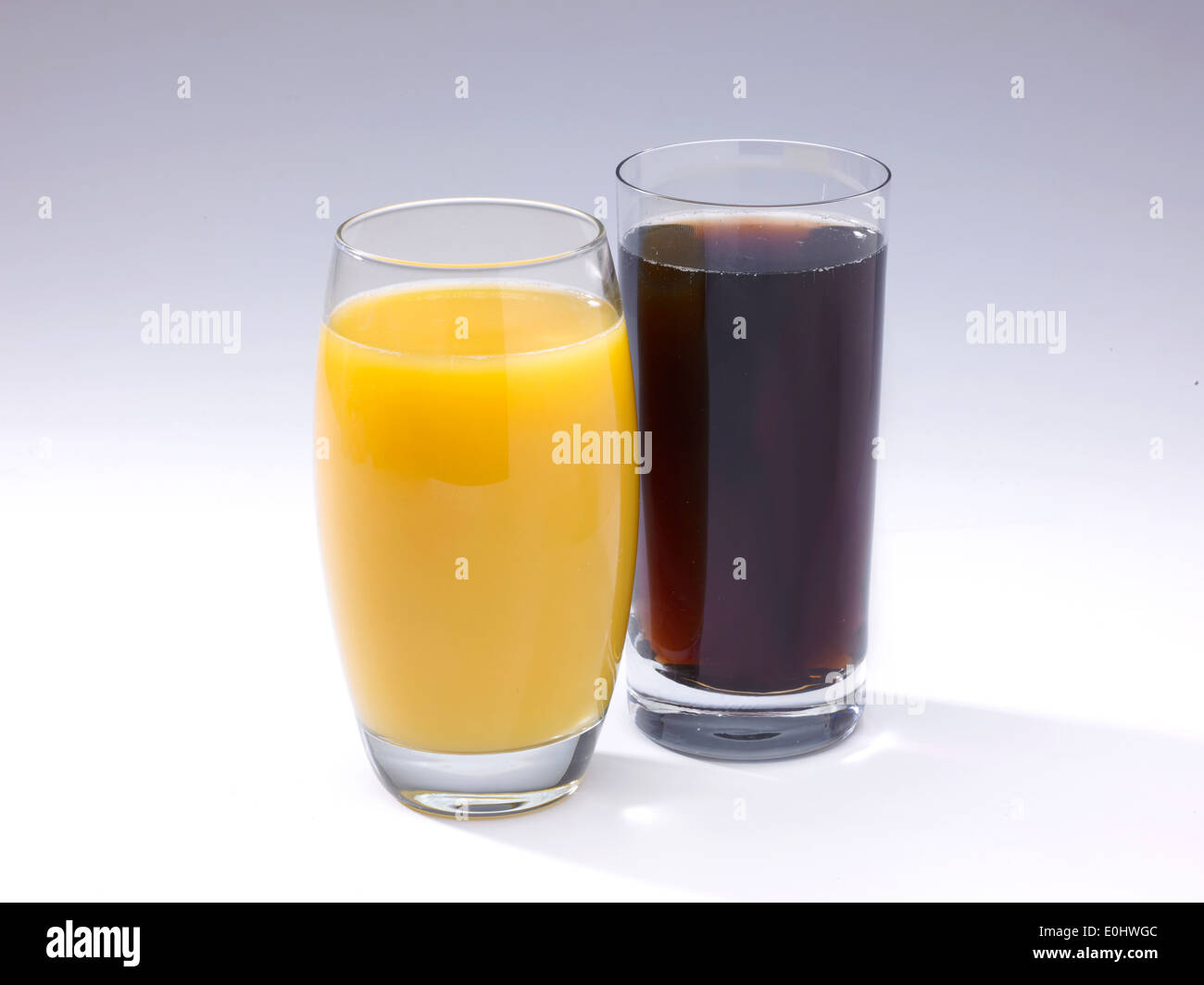 Un vaso de zumo de naranja y bebida cola sobre un fondo blanco Fotografía  de stock - Alamy