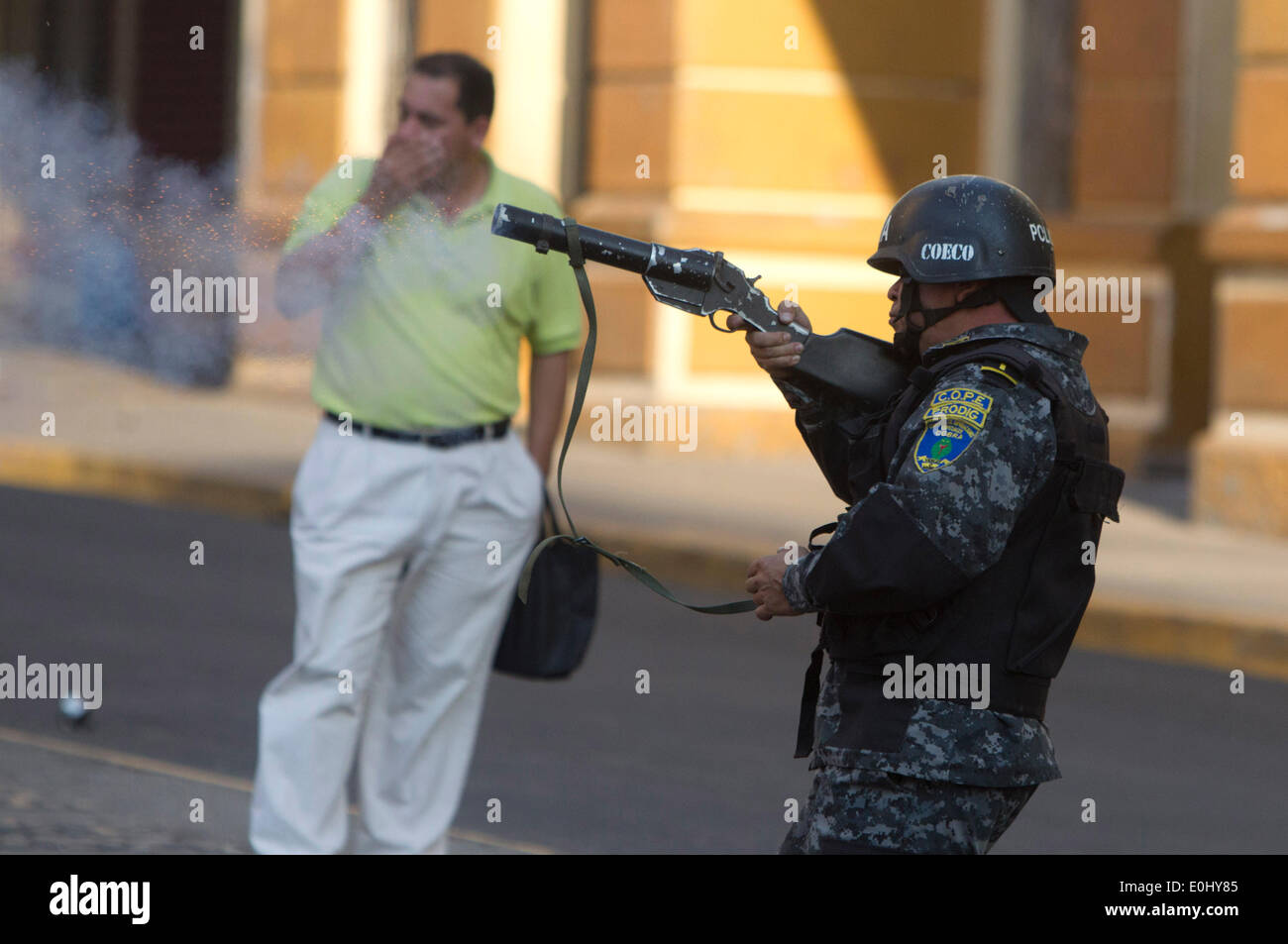 Tegucigalpa, Honduras. El 13 de mayo de 2014. Un elemento de policía participa en un enfrentamiento contra los seguidores del ex presidente hondureño Manuel Zelaya en frente del Congreso Nacional, en Tegucigalpa, Honduras, el 13 de mayo de 2014. Seguidores y diputados del Partido libertad y Refundación (Libre, por sus siglas en inglés), la segunda fuerza política en Honduras, irrumpieron en el Congreso Nacional el martes, después de chocar con los elementos de policía que protegía el Palacio Legislativo. Crédito: Rafael Ochoa/Xinhua/Alamy Live News Foto de stock