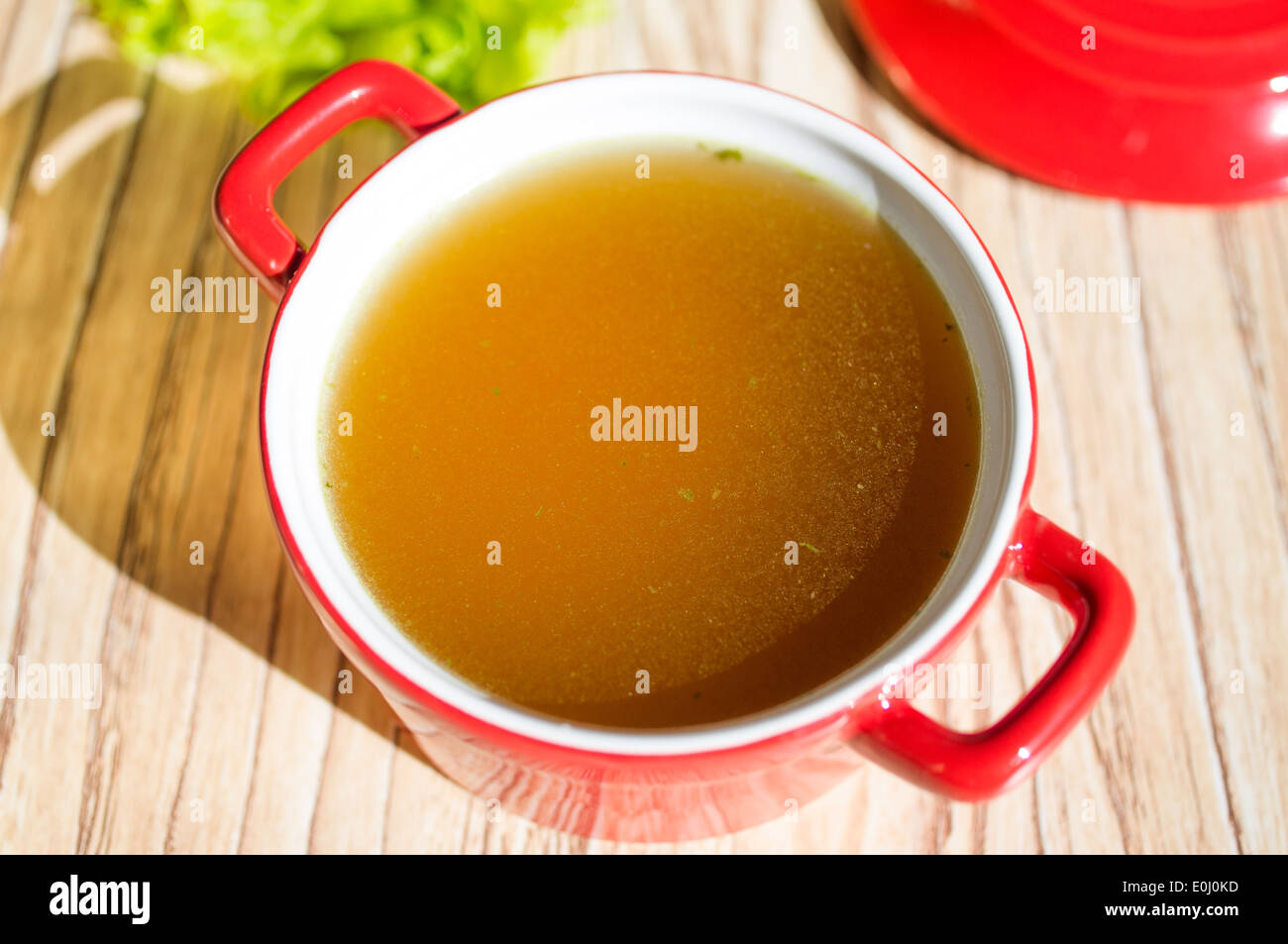 Caldo de pollo, caldo de pollo, la sopa en una taza junto a hierbas frescas  Fotografía de stock - Alamy