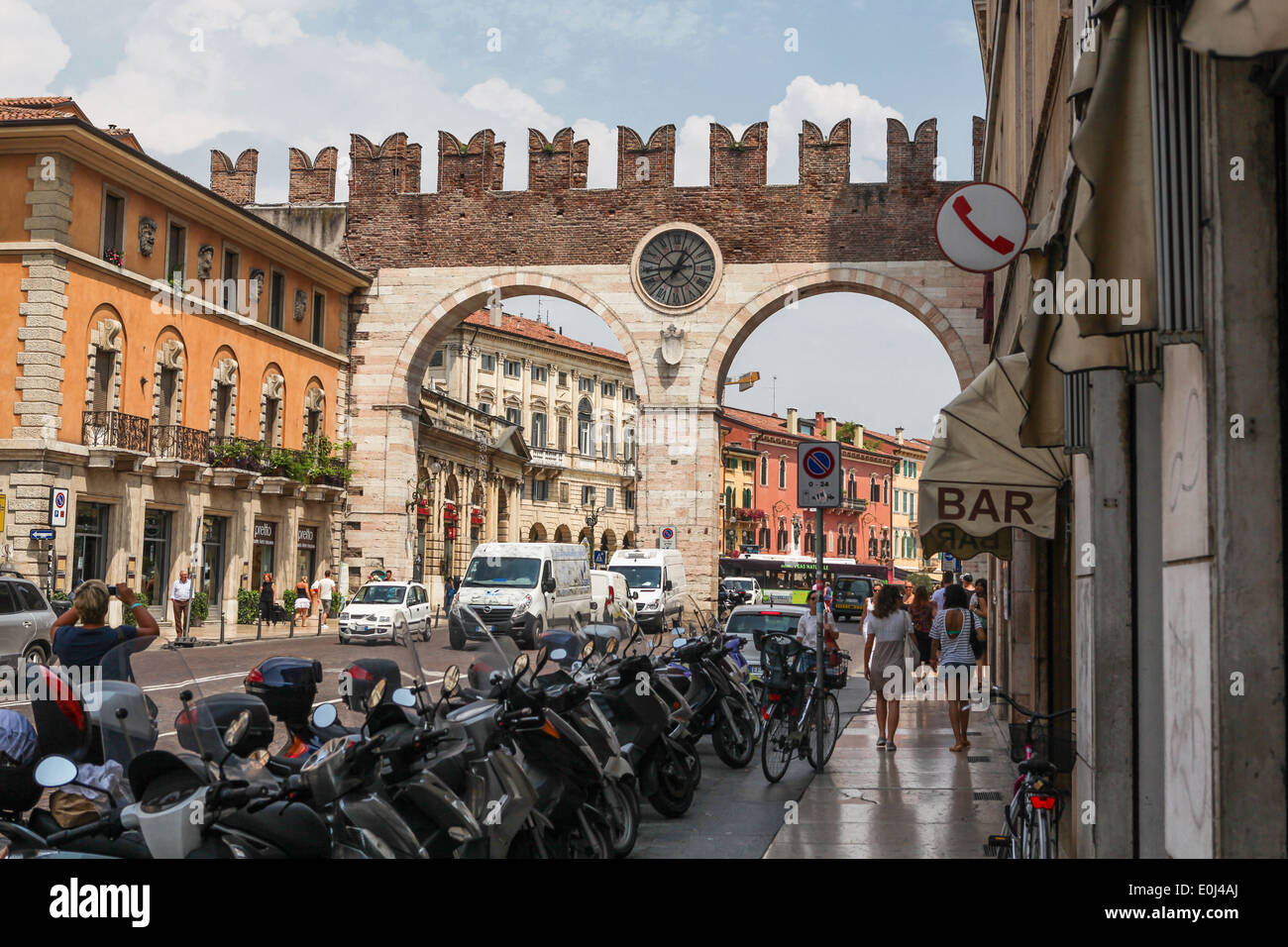 Concurrida calle de Verona con Portoni della Bra, puerta medieval que conduce a la Piazza Bra en el centro histórico de la ciudad. Foto de stock