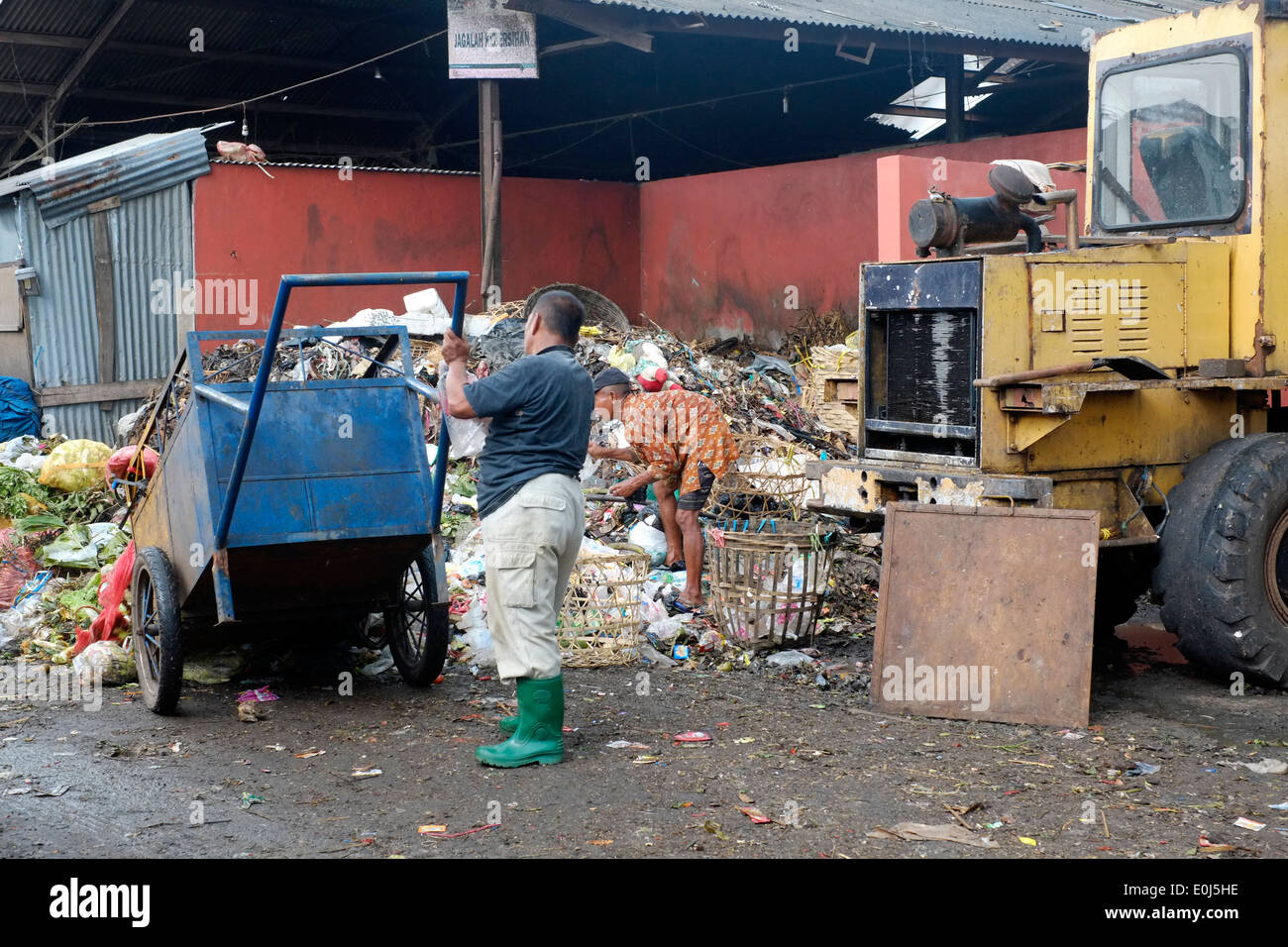 Hombre trabajando en un local de montón de fétida basura en un vertedero público en Malang, indonesia Foto de stock