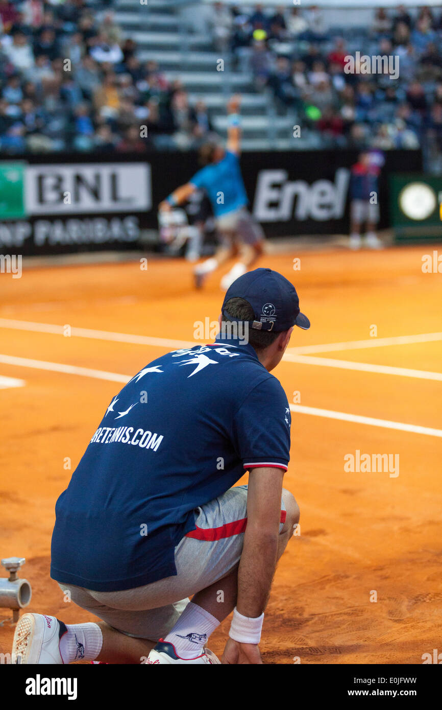 Ball boy en el lado de la corte mientras Rafael Nadal sirve en partido de tenis Foto de stock