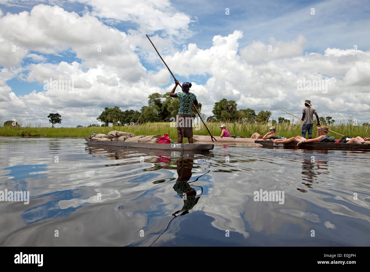 Los turistas en un tradicional barco mokoro en el Delta del Okavango, Botswana, África Foto de stock
