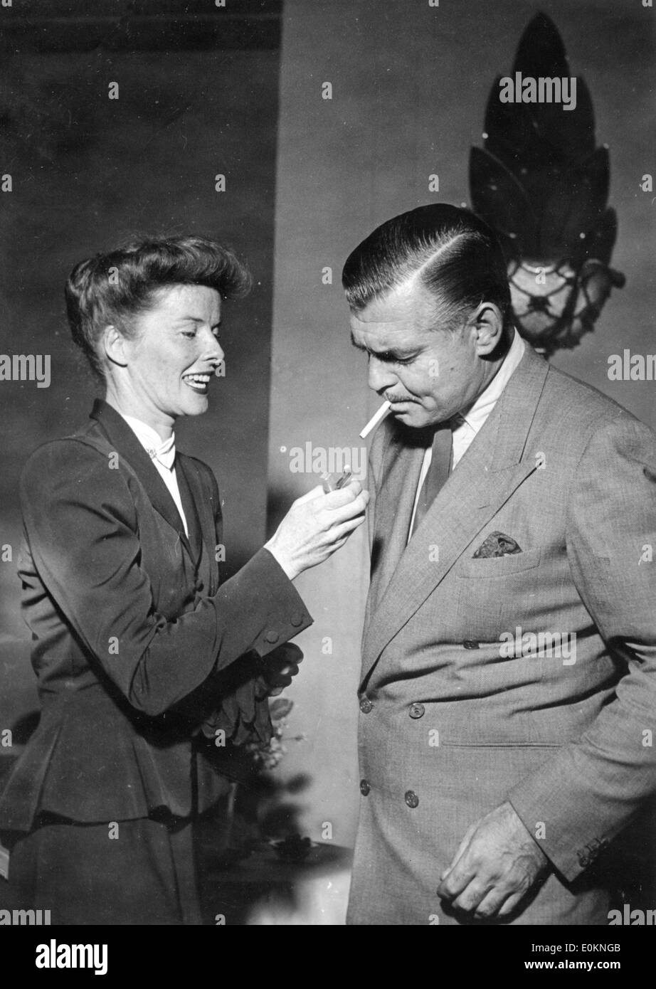 Actriz Katharine Hepburn enciende un cigarrillo para Clark Gable Foto de stock