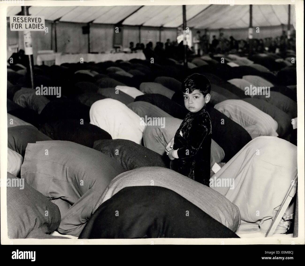 Jun 04, 1954 - Little Man - ¿Y ahora qué? Una joven en un mar de espaldas: El muchacho estaba en la mezquita oscura donde todos pero que estaban arrodilladas. Solos en un mar de espaldas perdidos en la oración silenciosa. No es de extrañar, entonces, el oscuro, ojos redondos de cuatro años Khurshid Ahmed llenar con alarma repentina. Su situación es retratada en la mezquita Shah Jehan Ala, Surrey, donde los musulmanes se reunieron ayer en la celebración de la ''Id al-Fitr Festival. Foto de stock