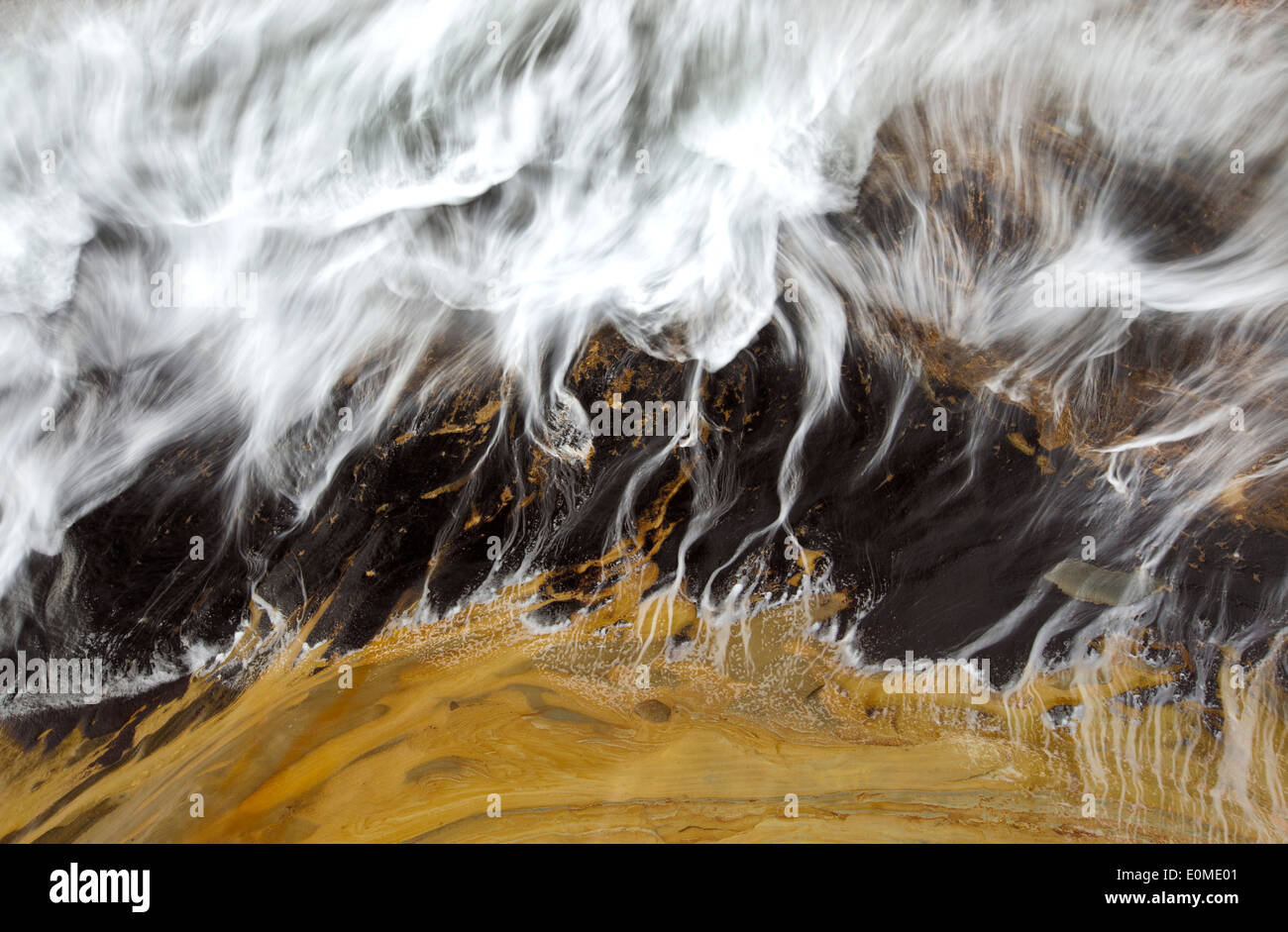Una larga exposición desenfoca una ola hundida en el Cabo Kiwanda, Costa de Oregón, EE.UU. Foto de stock