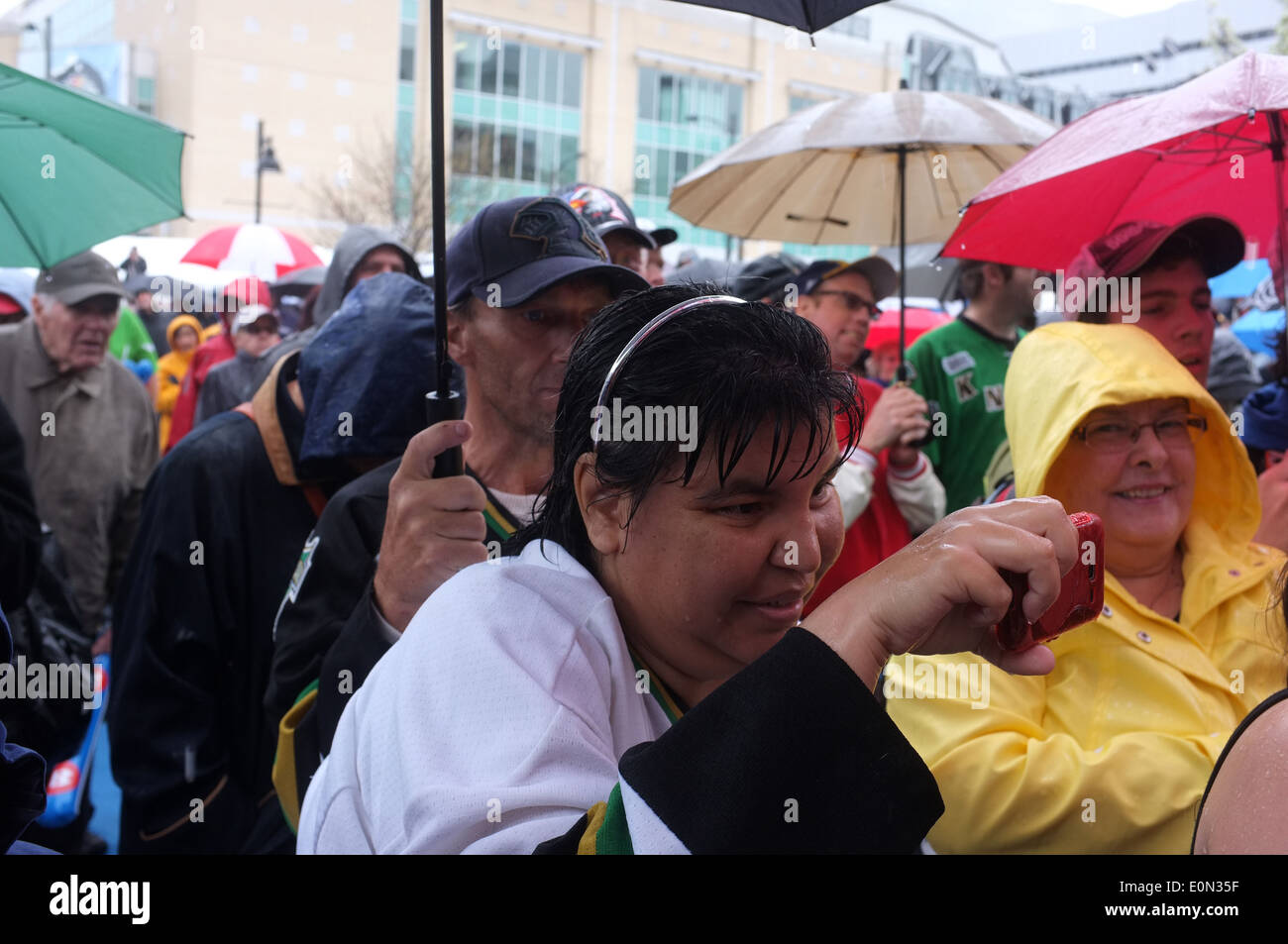 Las multitudes stand bajo paraguas en la lluvia. Foto de stock