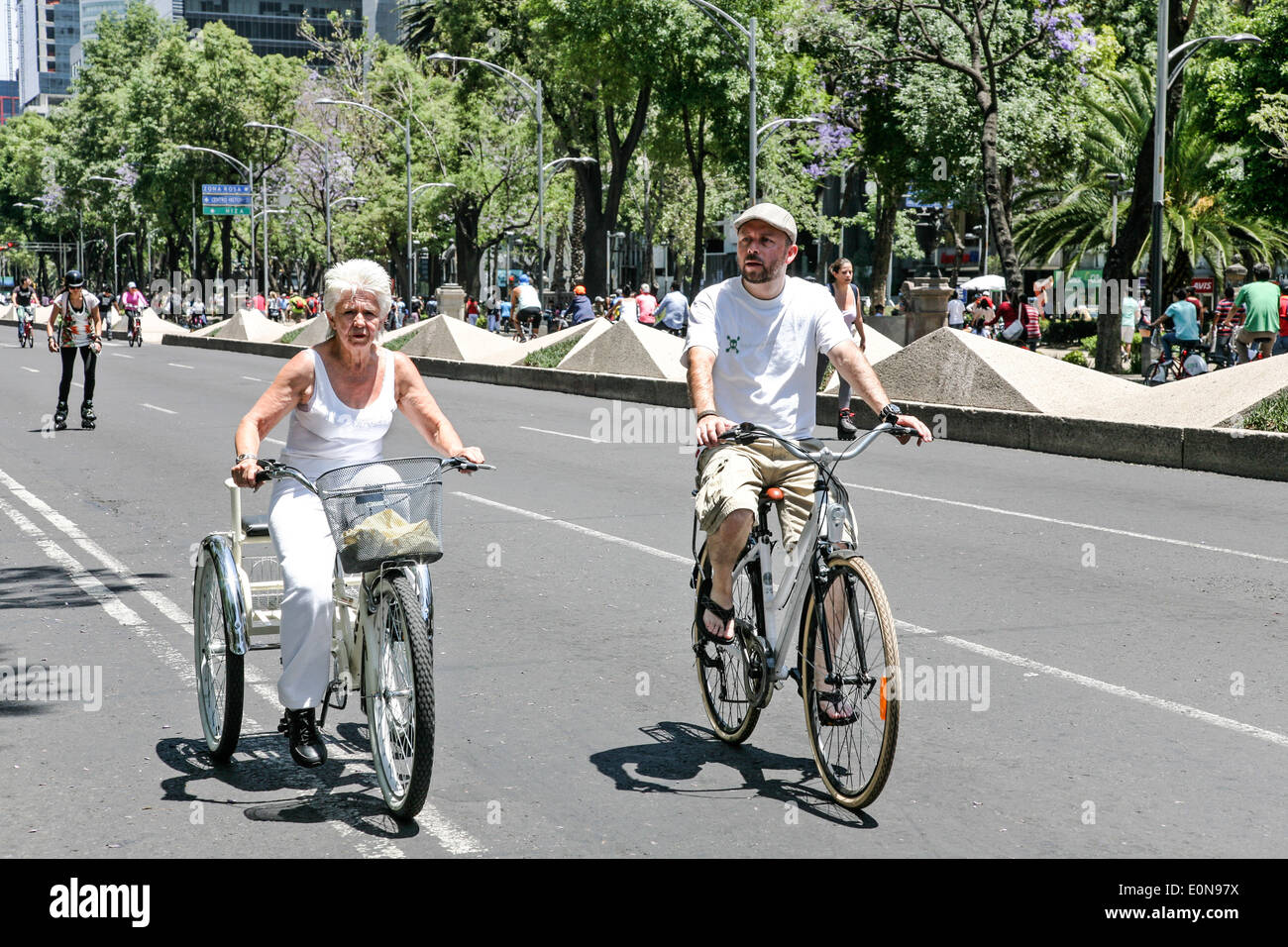 Bastante vieja dama en blanco sobre el ciclo 3 ruedas goza de libre tráfico de Paseo de la Reforma con ciclista amigo glorioso domingo de primavera Foto de stock