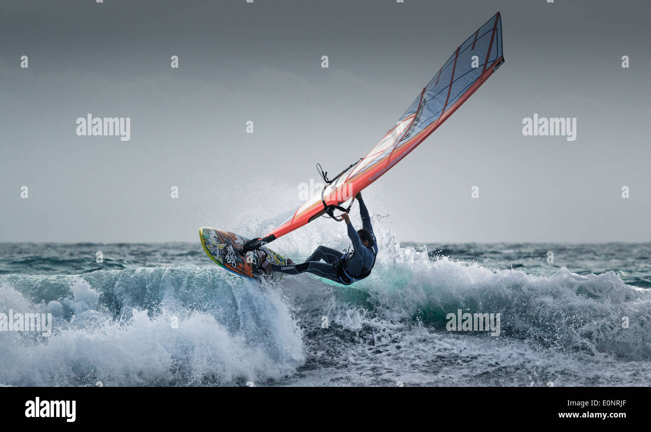 La windsurfista montando una onda. Foto de stock