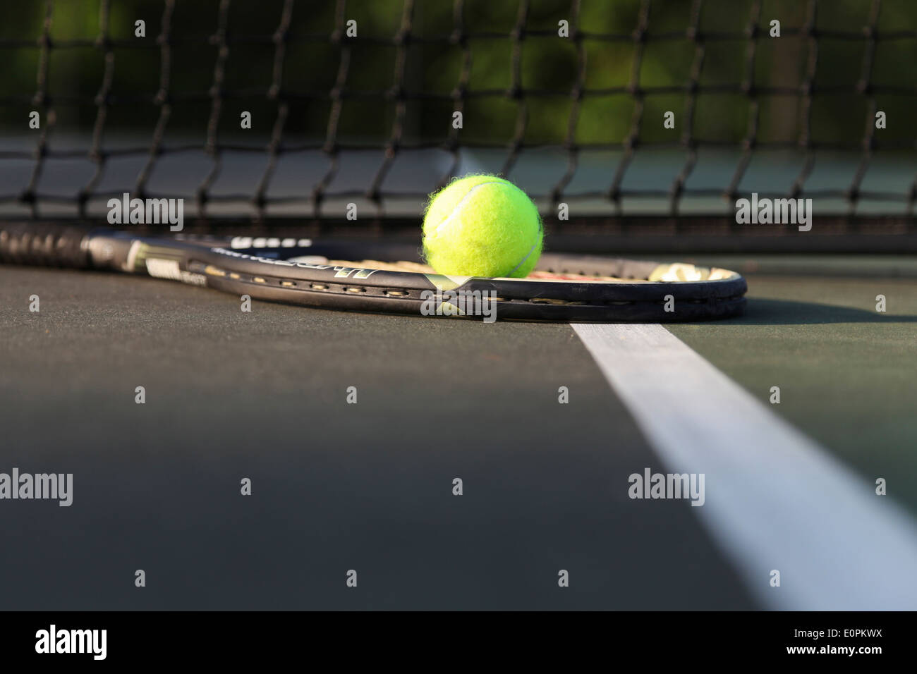 Raqueta de tenis y la bola en la cancha por net. Foto de stock