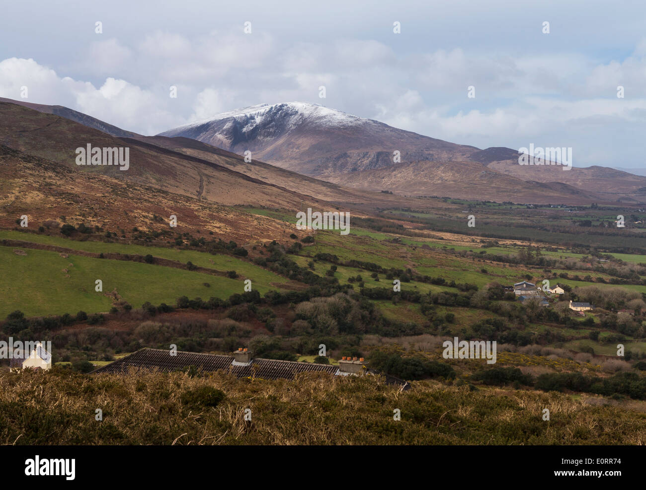 Paisaje de Irlanda en el condado de Kerry, cerca de Dingle en la República de Irlanda, con nieve en las montañas en la distancia Foto de stock