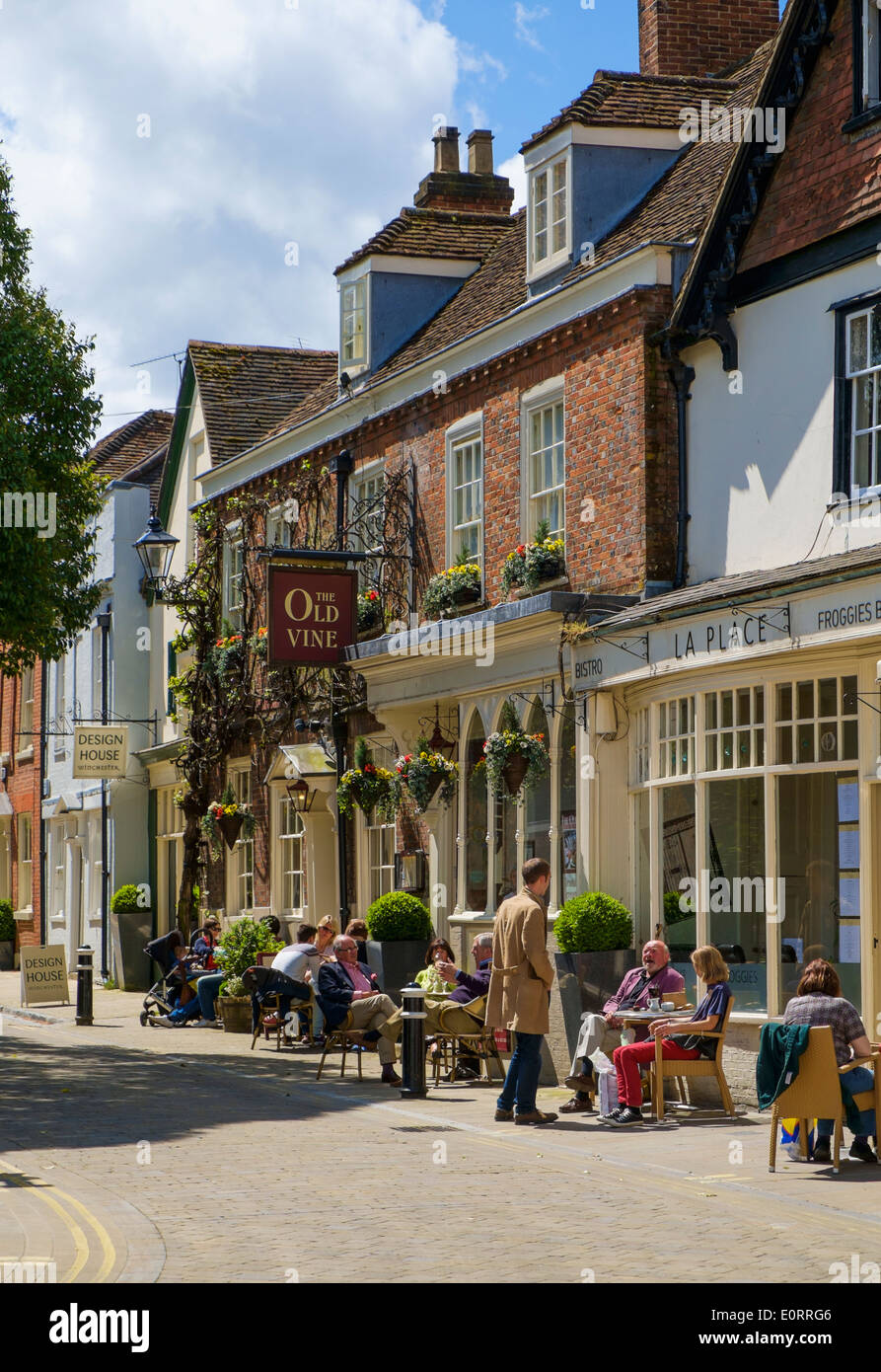 Viejo pub y cafés en Winchester, Hampshire, Inglaterra, Reino Unido, con personas sentadas disfrutando del sol Foto de stock