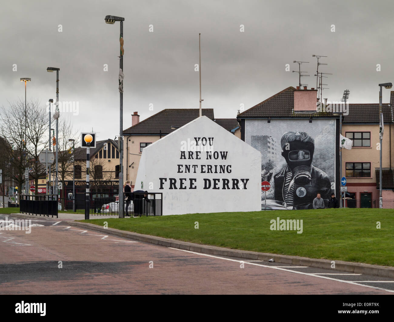 Firmar entrando en Derry libre con mural de Bogside Artists en el lateral de la casa de Derry, Irlanda del Norte Foto de stock