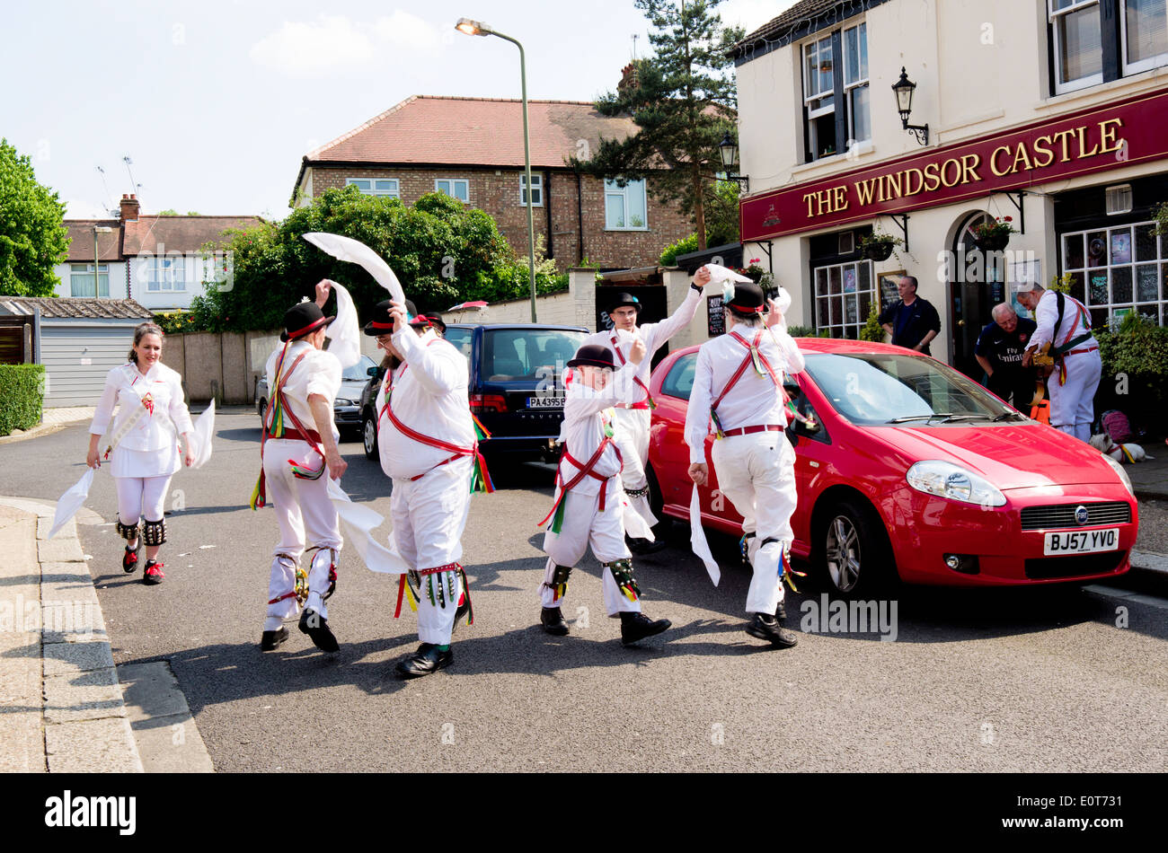 Morris bailarines practican fuera de su danza folklórica fuera del castillo de Windsor pub. Foto de stock