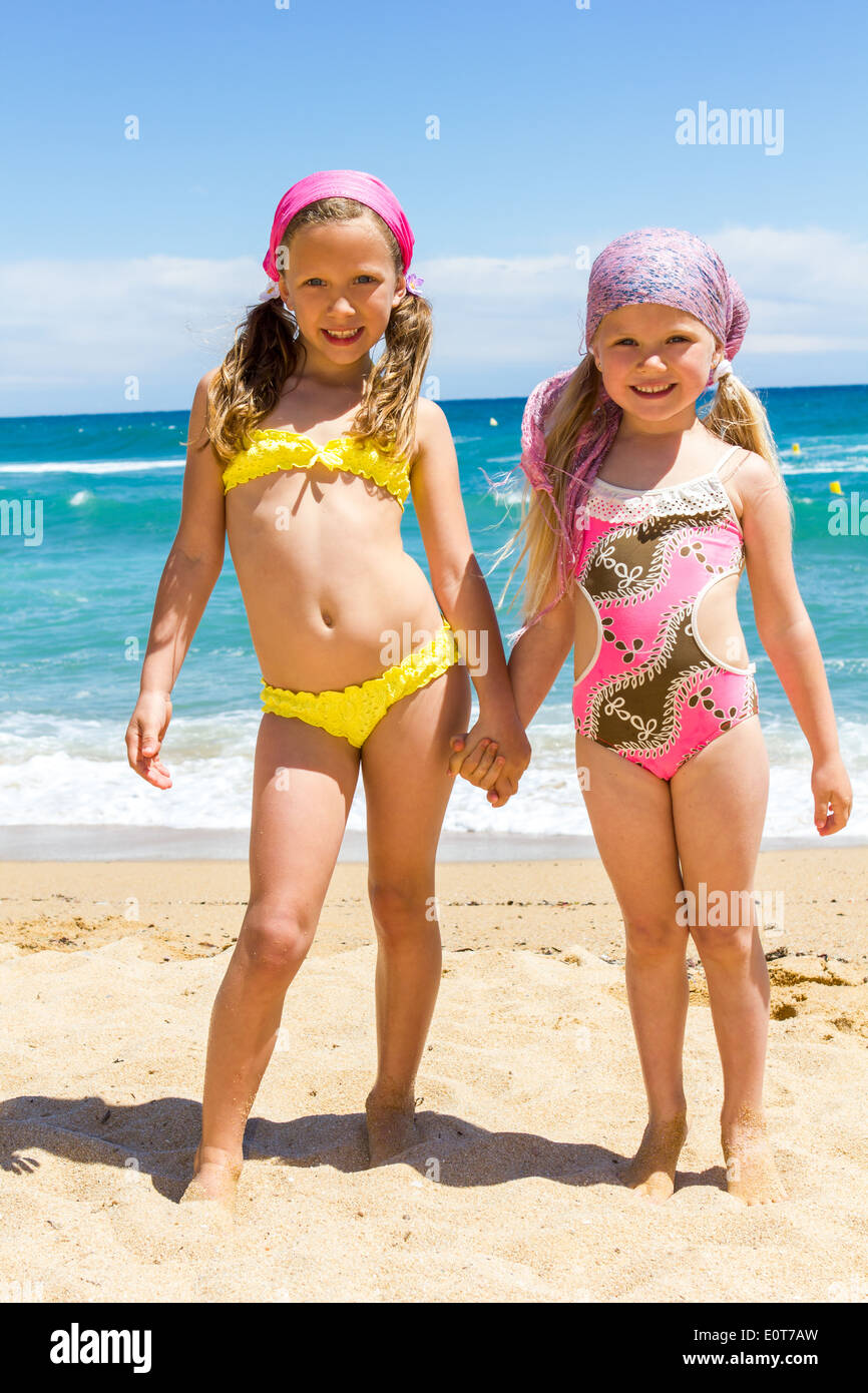 Dos niñas en traje de baño en la playa Fotografía de stock - Alamy
