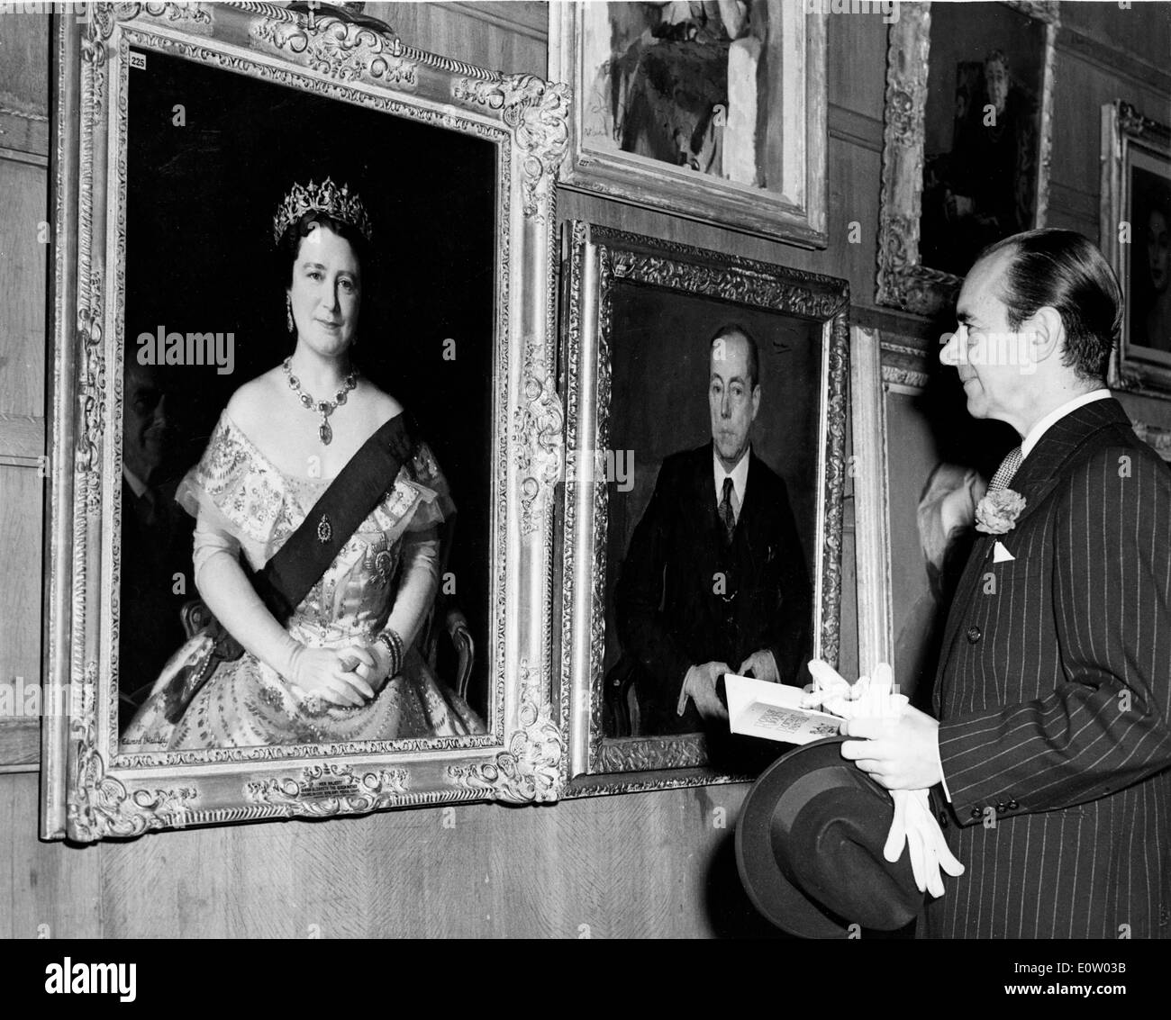 Malcolm Sargent mirando los retratos de la Reina Foto de stock
