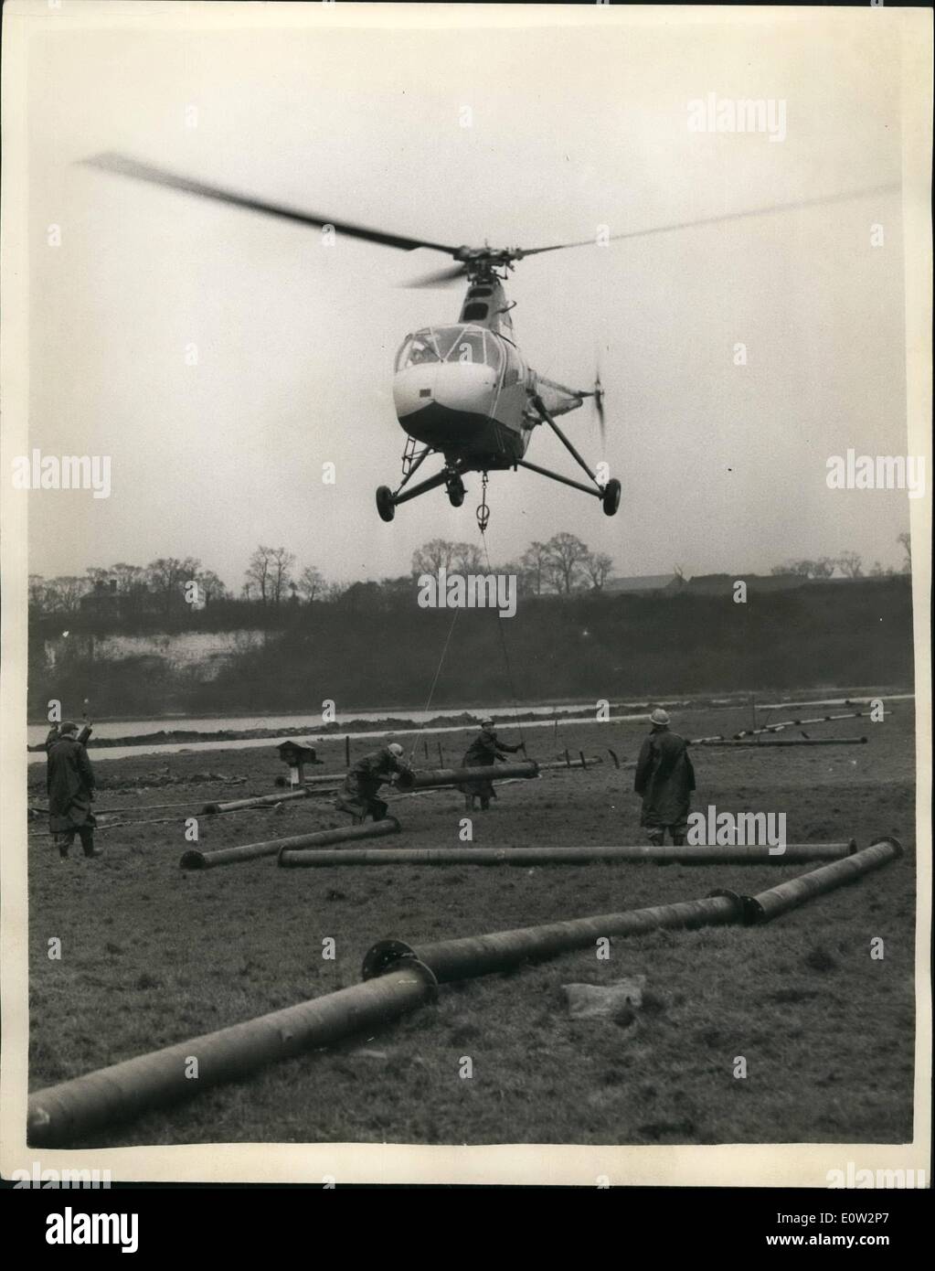 Enero 01, 1961 - Funcionamiento oleoducto. Experimento por helicóptero sobre los pantanos de Kent.: Un experimento fue llevado en helicóptero a través de los pantanos a Thames, cerca Gravesond Cliffo, Kent con la colocación de tubo de acero, con la ayuda de un helicóptero. A media milla de 8" de diámetro nominal del tubo de heces, compuesto de 100 longitudes de brida - cada 20 m de largo y pesan 4 Cwt. La tarea fue llevada a cabo por la British United Airways Widgeon - piloteado por el ex-piloto de la Marina Mike Perkis. El trabajo -que normalmente tendrían diez a catorce días, terminó hoy en cuestión de horas. Foto de stock