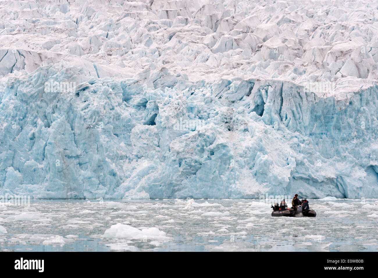 Los turistas a bordo de un bote de goma en la parte delantera de la llanta del Glaciar Monacobreen Liefdefjorden, Spitsbergen, Islas Svalbard Foto de stock
