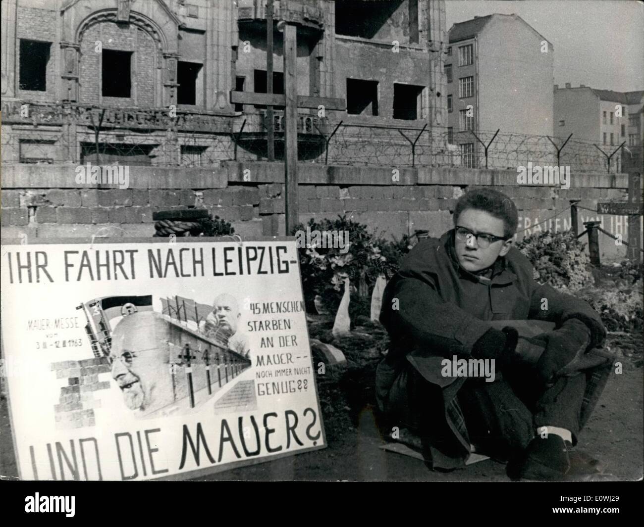 Marzo 03, 1963 - 19 años Westberliner pretende considerar la West-German y otros hombres de negocios occidentales. Él protestó contra los empresarios que están conduciendo a Leipzig para la zona Oriente exposición, no obstante la pared. Él se sentará durante tres días en el memorial de la filmación Eastberliner Peter Fechter. ~~~~ su lugar fue una pancarta con las palabras 50 va a la Feria de Leipzig y qué acerca de la pared?'', 45 personas murieron en la pared - no en~~gh. Foto de stock