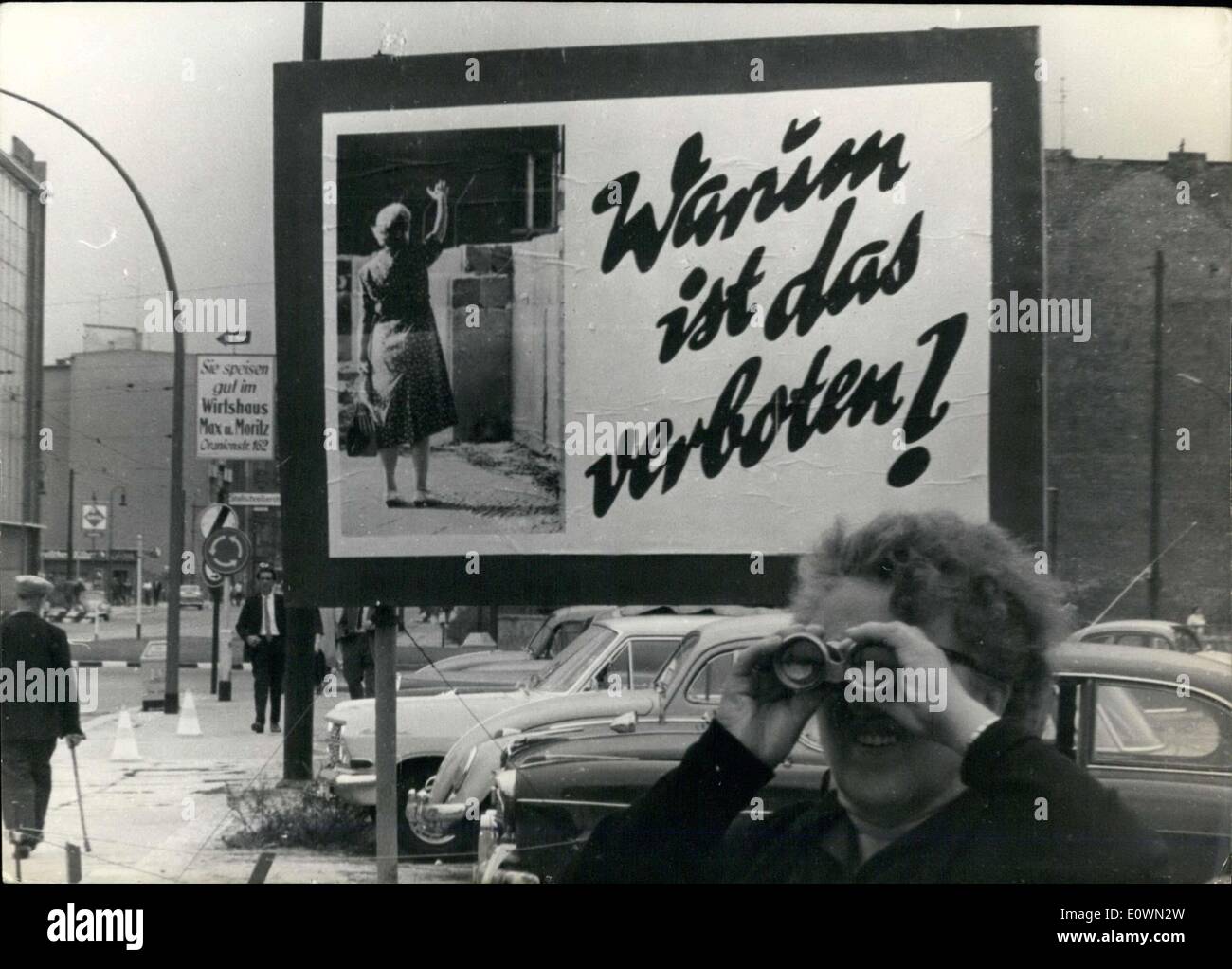 Agosto 12, 1963 - Esta etiqueta fue creado a lo largo de todo el muro de Berlín occidental. Hace divertido el hecho de que el sector soviético ha prohibido la gente de agitar a los del otro lado. Esta etiqueta se muestra en Heinrich-Heine Street. Una vieja mujer mira a Berlín oriental con binoculares. Foto de stock