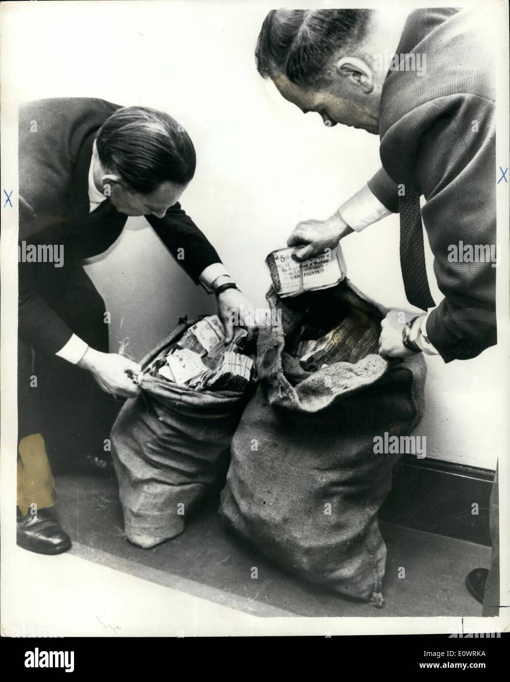 Diciembre 12, 1963 - Tren Robo dinero encontrado en Londres; dos sacos de patatas sucias que contenga unos ~50.000 en ~5 y ~1 notas robado en el gran robo del tren el pasado mes de agosto, se encontraron en un teléfono en el sur de Londres tras una llamada telefónica a Scotland Yard. La foto muestra dos detectives comprobando el dinero Scotland Yard. (De izquierda a derecha) Det. Inspector jefe Syd Bradbury y Det. Inap Frank Williams. Foto de stock
