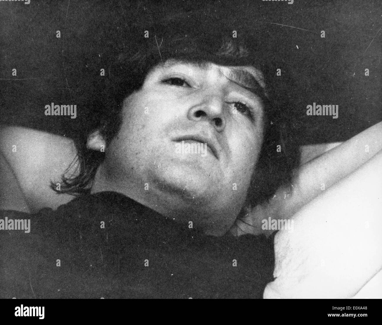 El cantante John Lennon sentando en la cama Foto de stock