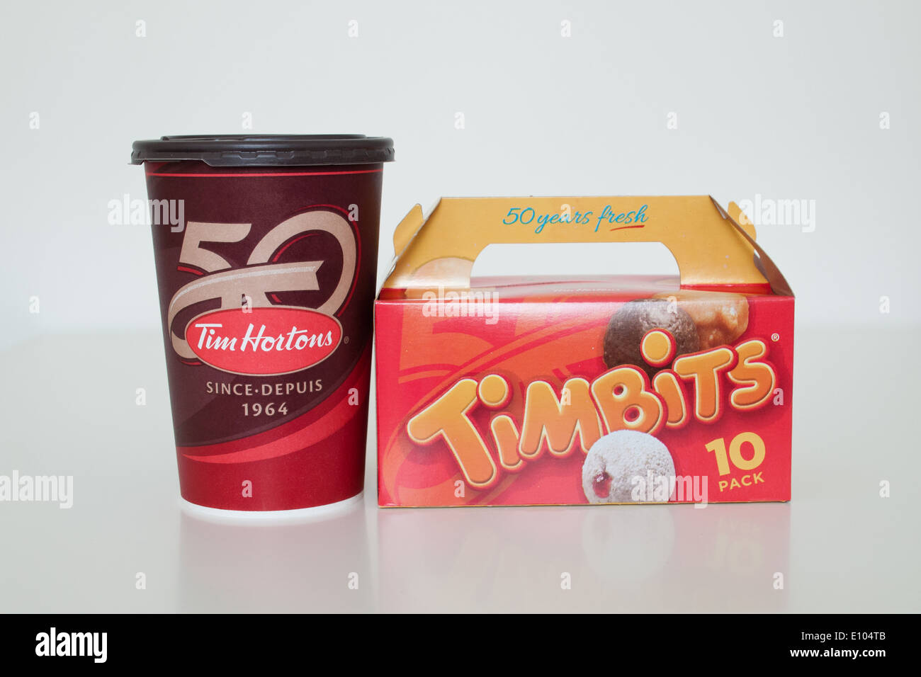 Una taza de café de Tim Hortons y Timbits (agujeros de donut, donut orificios). Canadá. Foto de stock