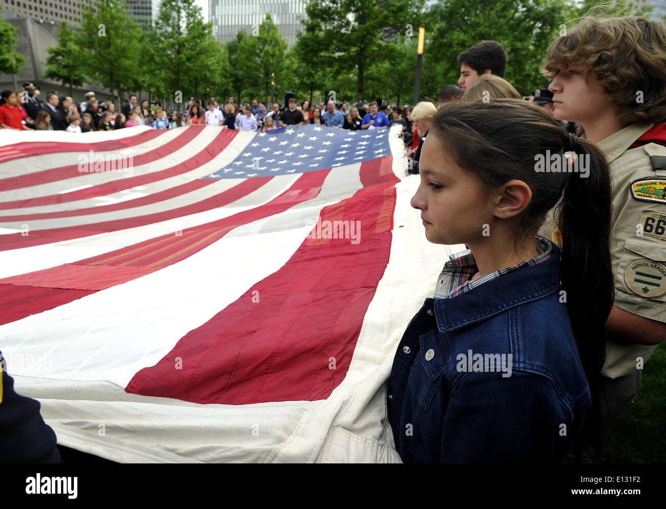 Nueva York, Estados Unidos. 21 de mayo de 2014. Los niños tienen la Bandera Nacional de 9/11 en frente del Museo Nacional conmemorativo del 11 de septiembre en Nueva York, Estados Unidos, 21 de mayo de 2014. El museo memorial del miércoles se abrió al público en general después de la ceremonia de traspaso de la Bandera Nacional 11/09, una bandera americana que había volado en 90 West Street, adyacente a la Zona Cero, durante semanas después de los atentados, en la colección permanente del museo. Crédito: Wang Lei/Xinhua/Alamy Live News Foto de stock