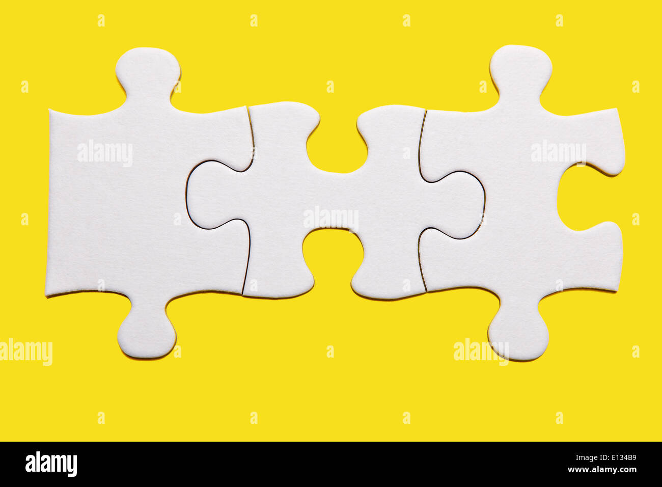Tres piezas de puzzle blanco sobre fondo amarillo Fotografía de stock -  Alamy
