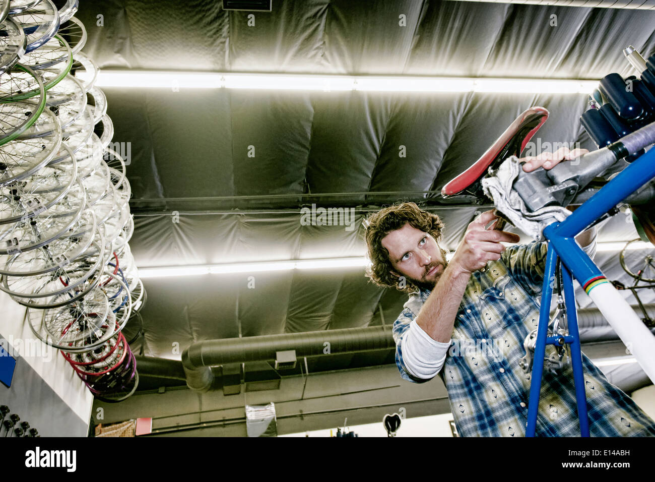 Hombre sonriendo caucásico en taller de reparación de bicicletas Foto de stock