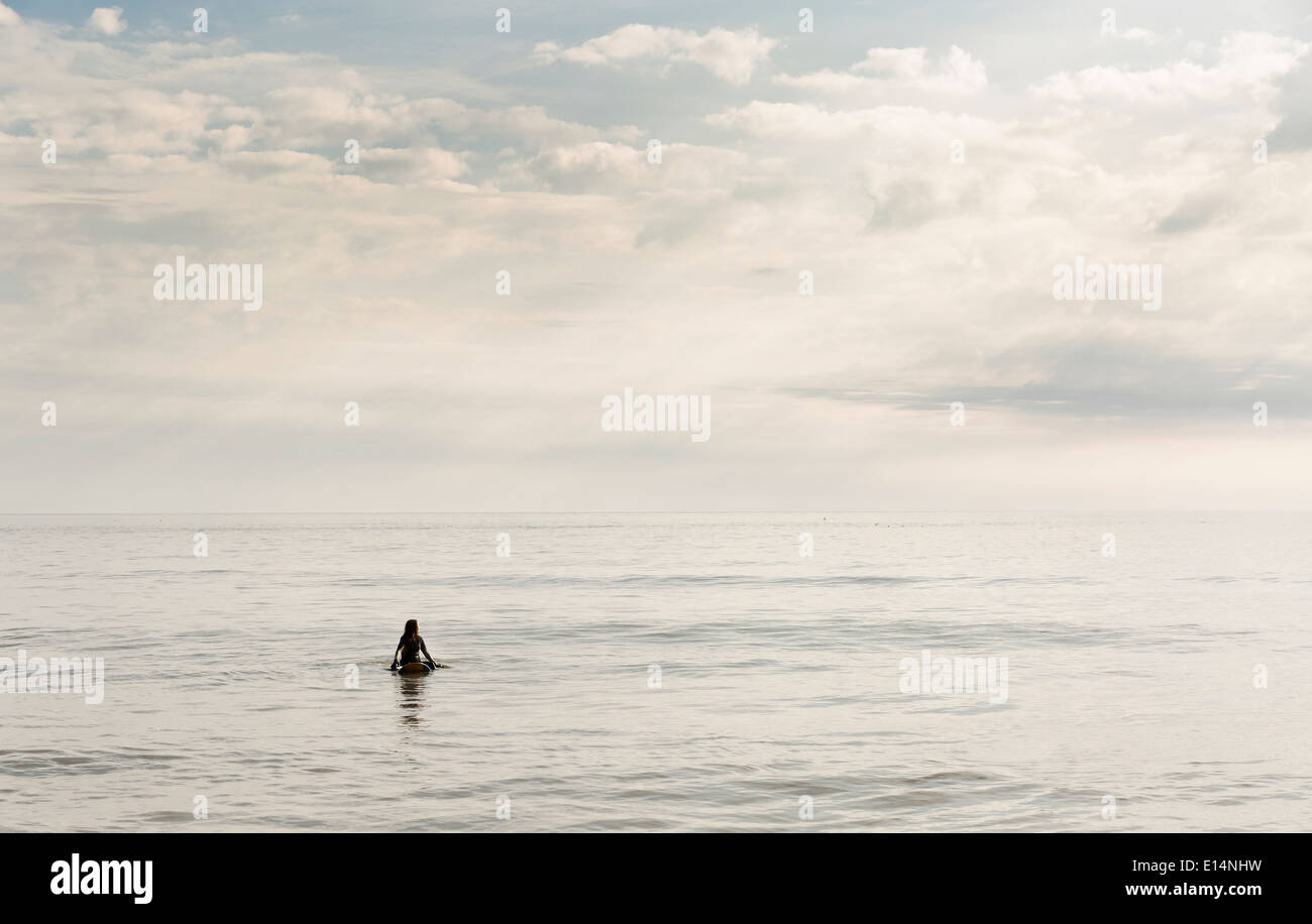 Hispanic surfer flotando en el agua Foto de stock