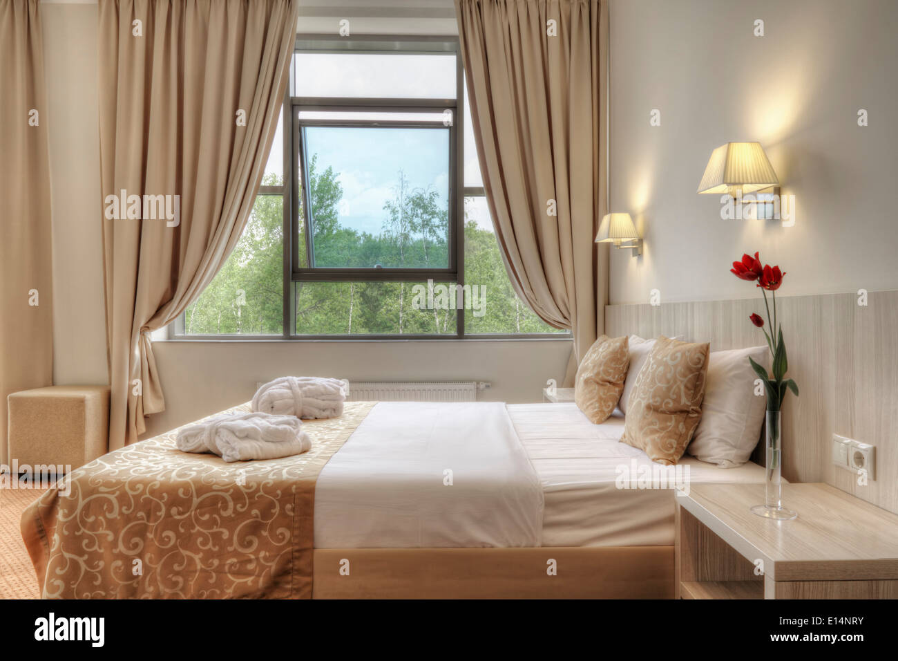 La cama y las cortinas en la habitación del hotel Foto de stock