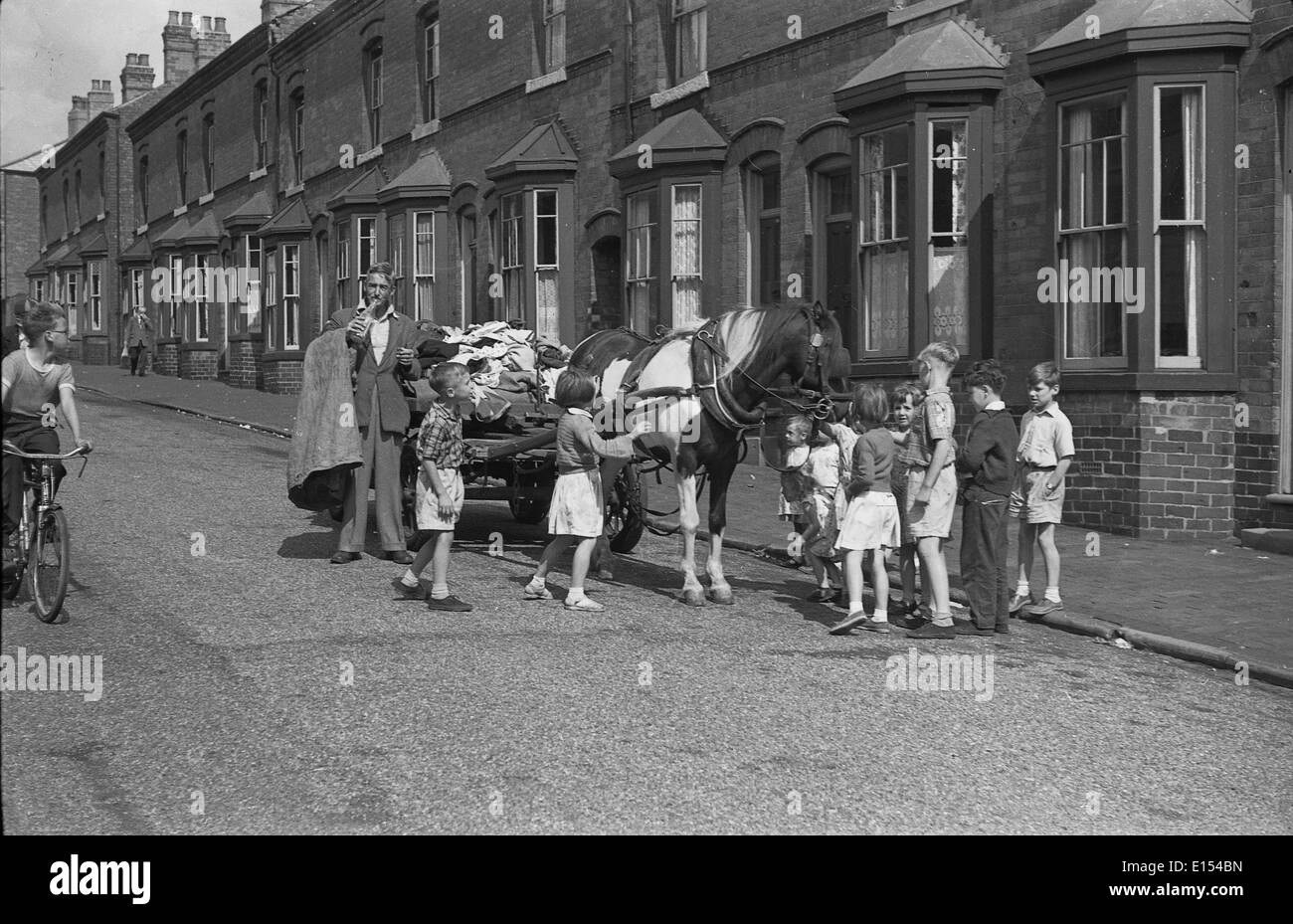 Rag y hueso hombre a caballo y carro, rodeado de niños de la calle en Birmingham West Midlands, Reino Unido de Gran Bretaña de 1950 Foto de stock