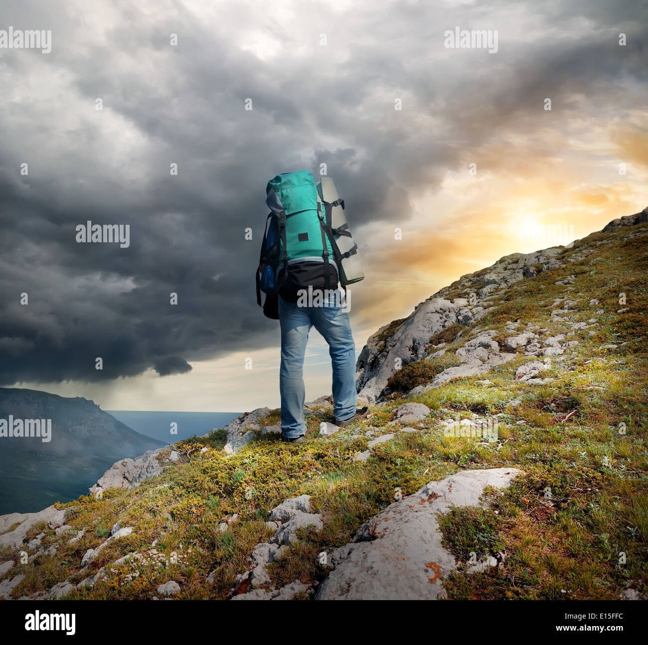 Backpacker en montañas bajo el trueno de las nubes Foto de stock