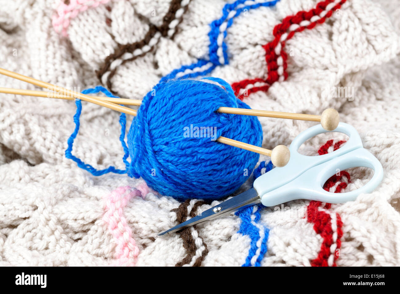 La bola de hilo azul con aguja de tejer y tijeras Foto de stock