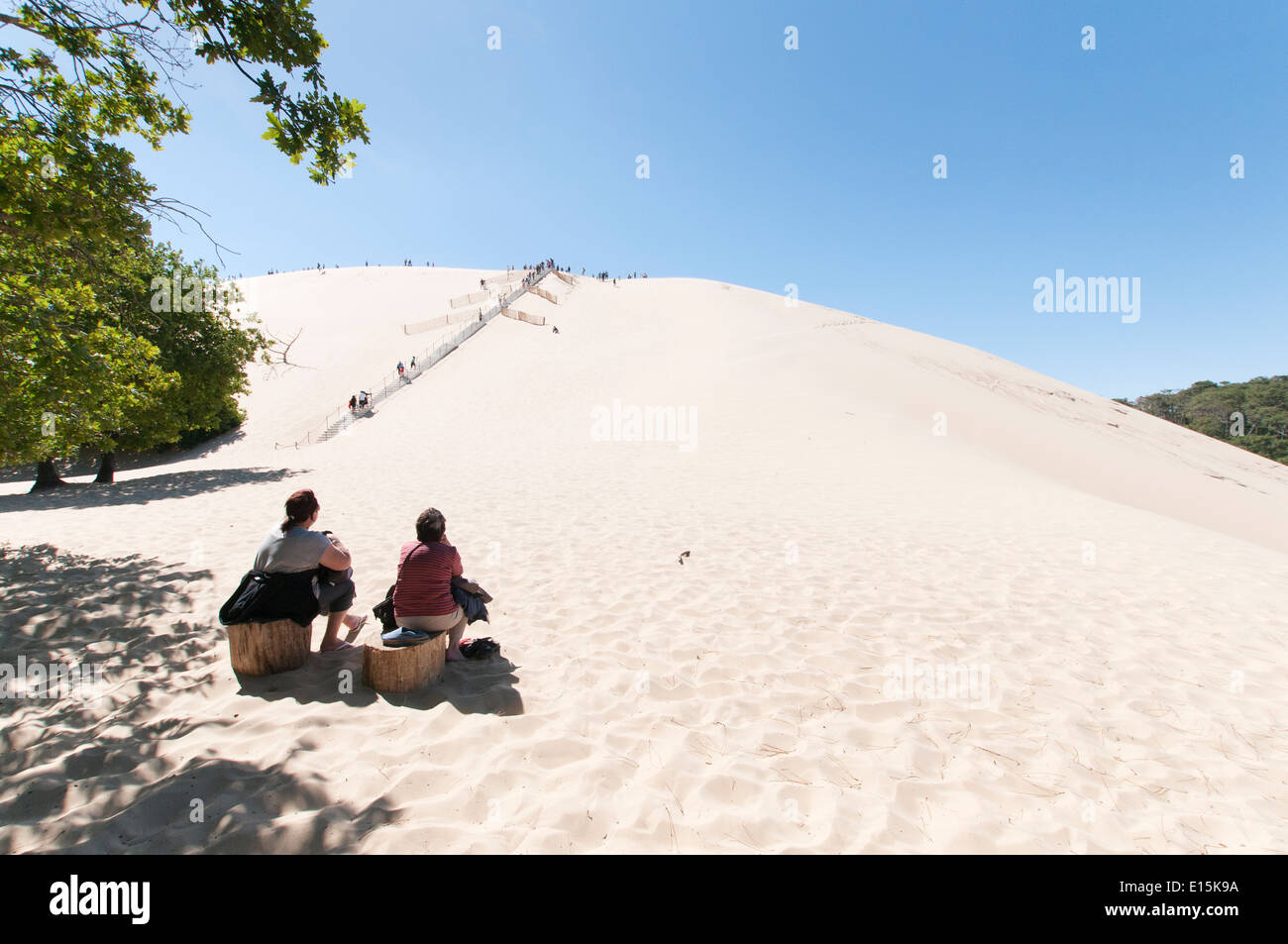 Francia, Gironda, el Bassin d'Arcachon (Arcachon Bay). Dos mujeres adultas ver visitantes subir los escalones hasta la cima de la duna de Pyla. Foto de stock