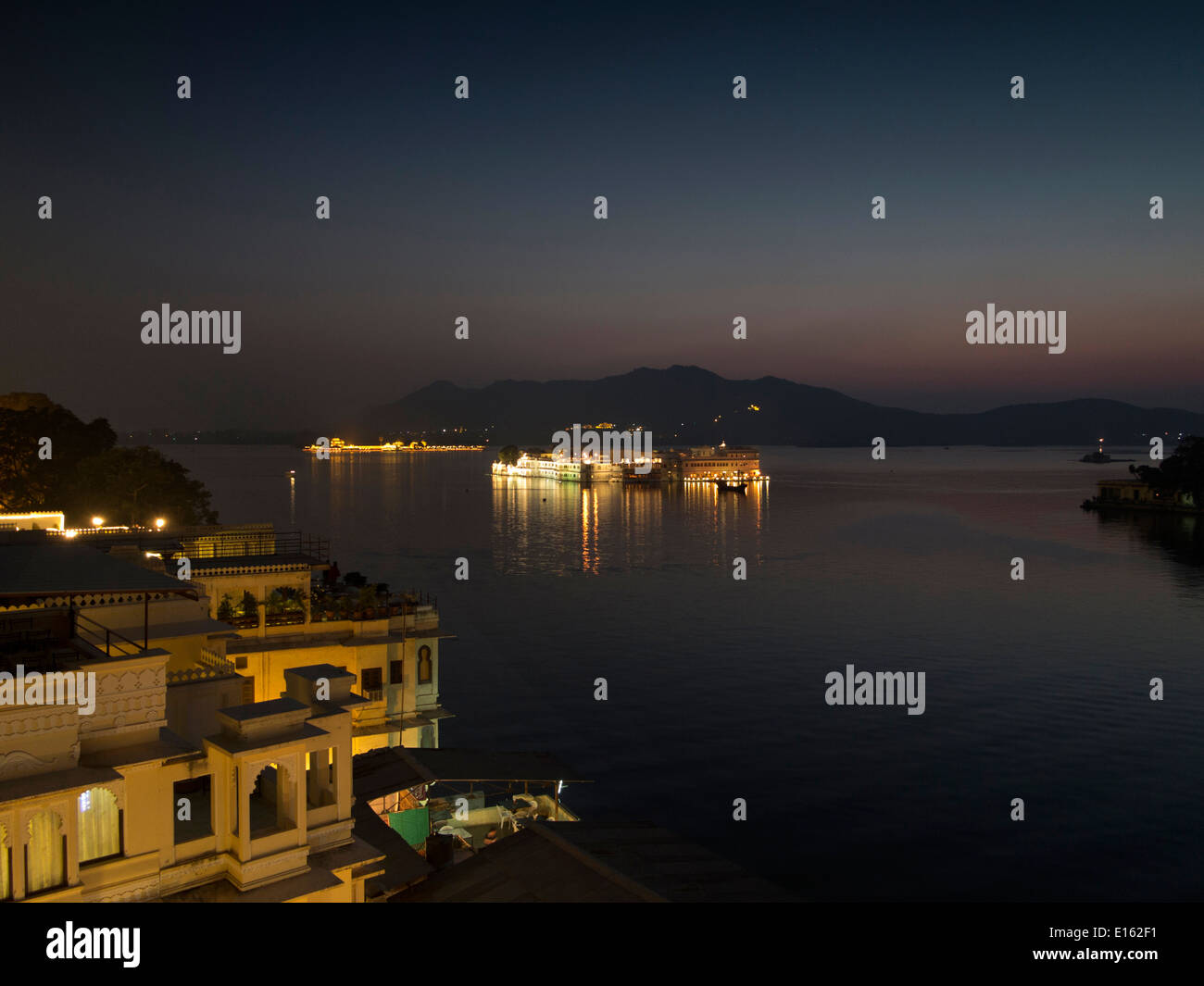 La India, Rajasthan, Udaipur, el lago Pichola y el Lake Palace Hotel, iluminada por la noche Foto de stock