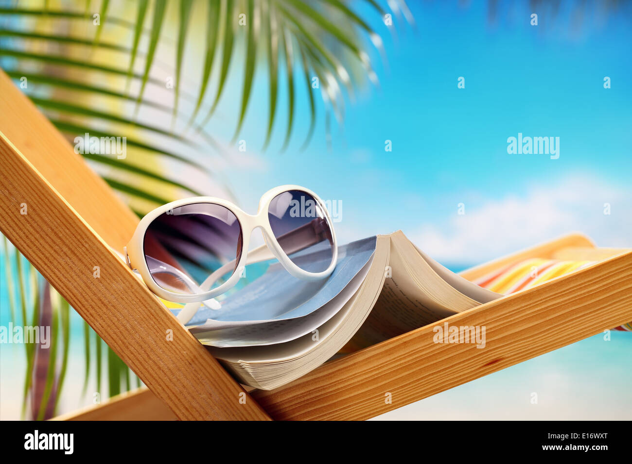 Ajuste de vacaciones de verano con el libro en la silla de playa Foto de stock