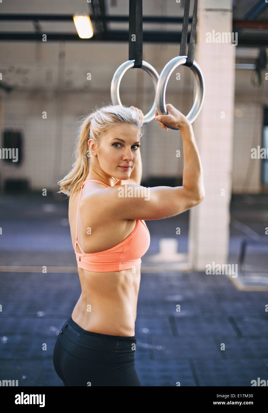 Colocar mujer utilizando el gimnasta aros como parte de un crossfit  entrenar en el gimnasio. Musculoso joven atleta femenina ejerciendo con  anillos Fotografía de stock - Alamy