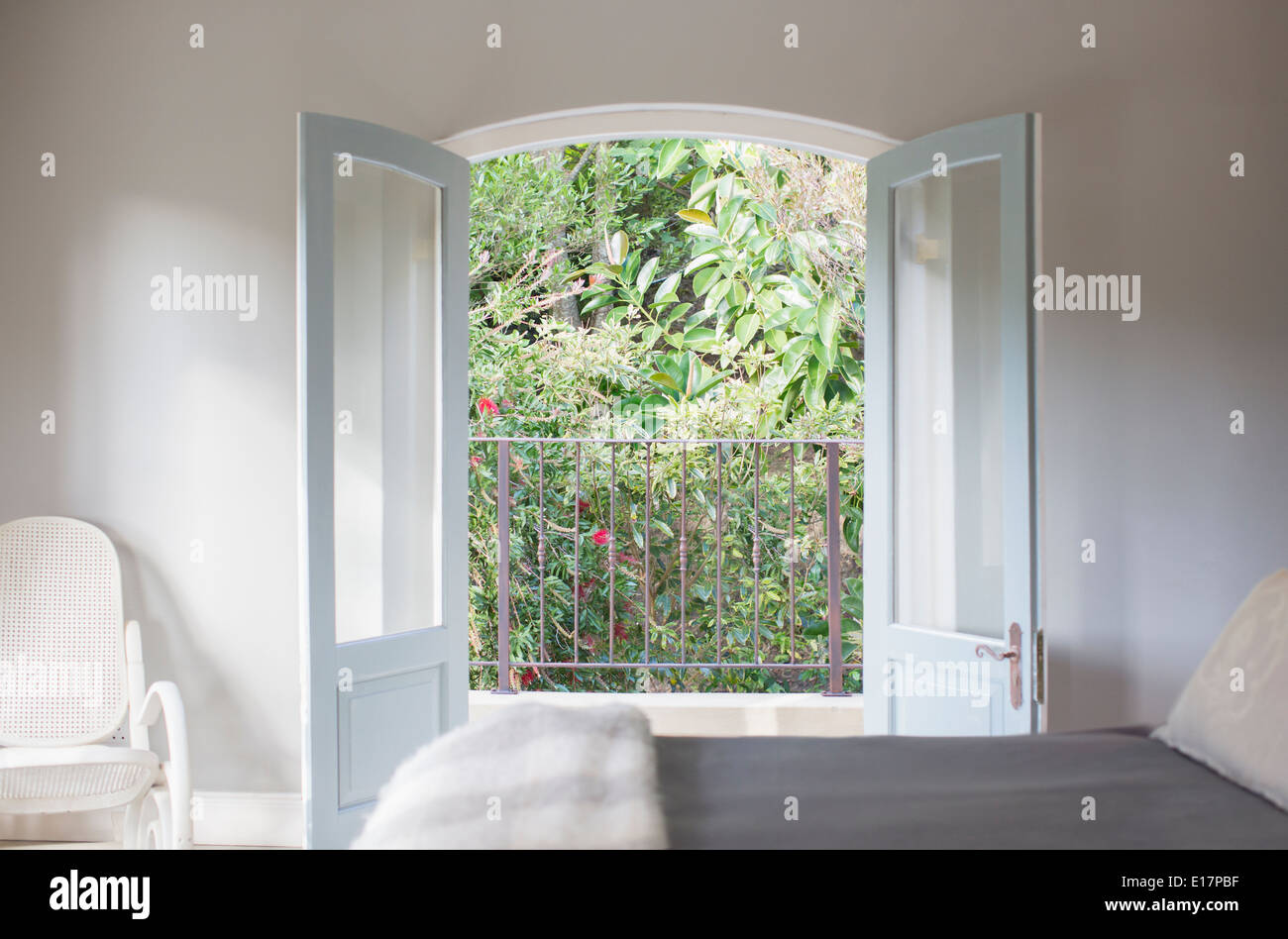 Las puertas francesas se abren a un balcón en la habitación de lujo Foto de stock