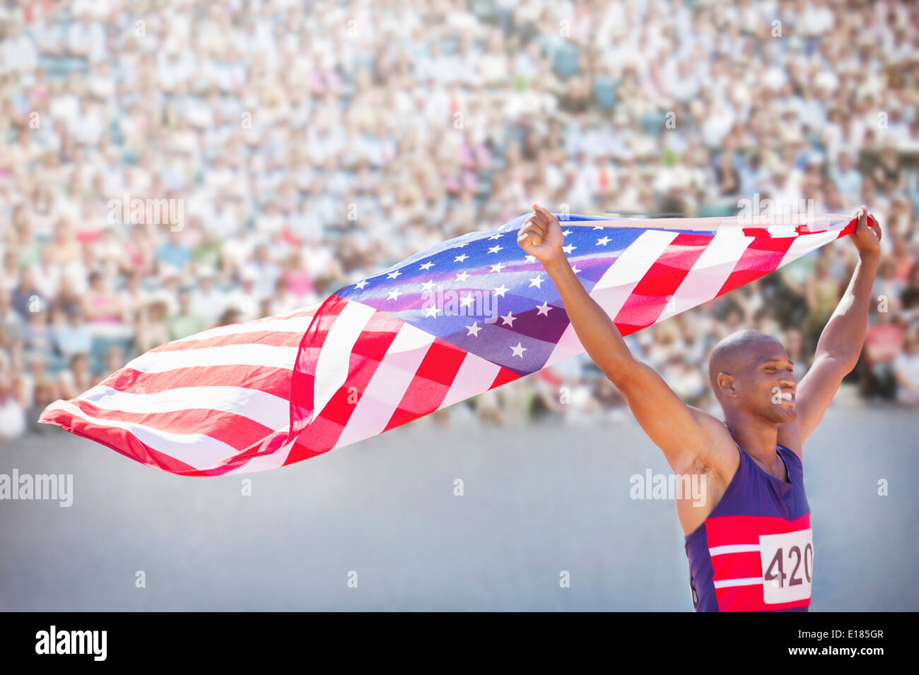 Atleta de pista y campo en el estadio sosteniendo la bandera americana Foto de stock