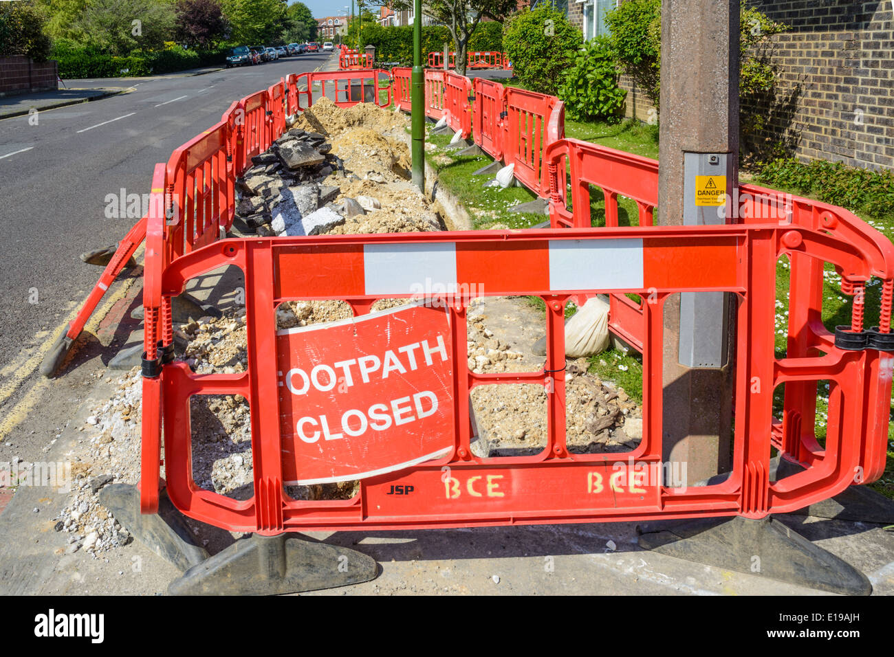 Sendero cerrado y barreras rojas donde los trabajos de reparación del pavimento está en marcha en una ruta en el Reino Unido. Foto de stock