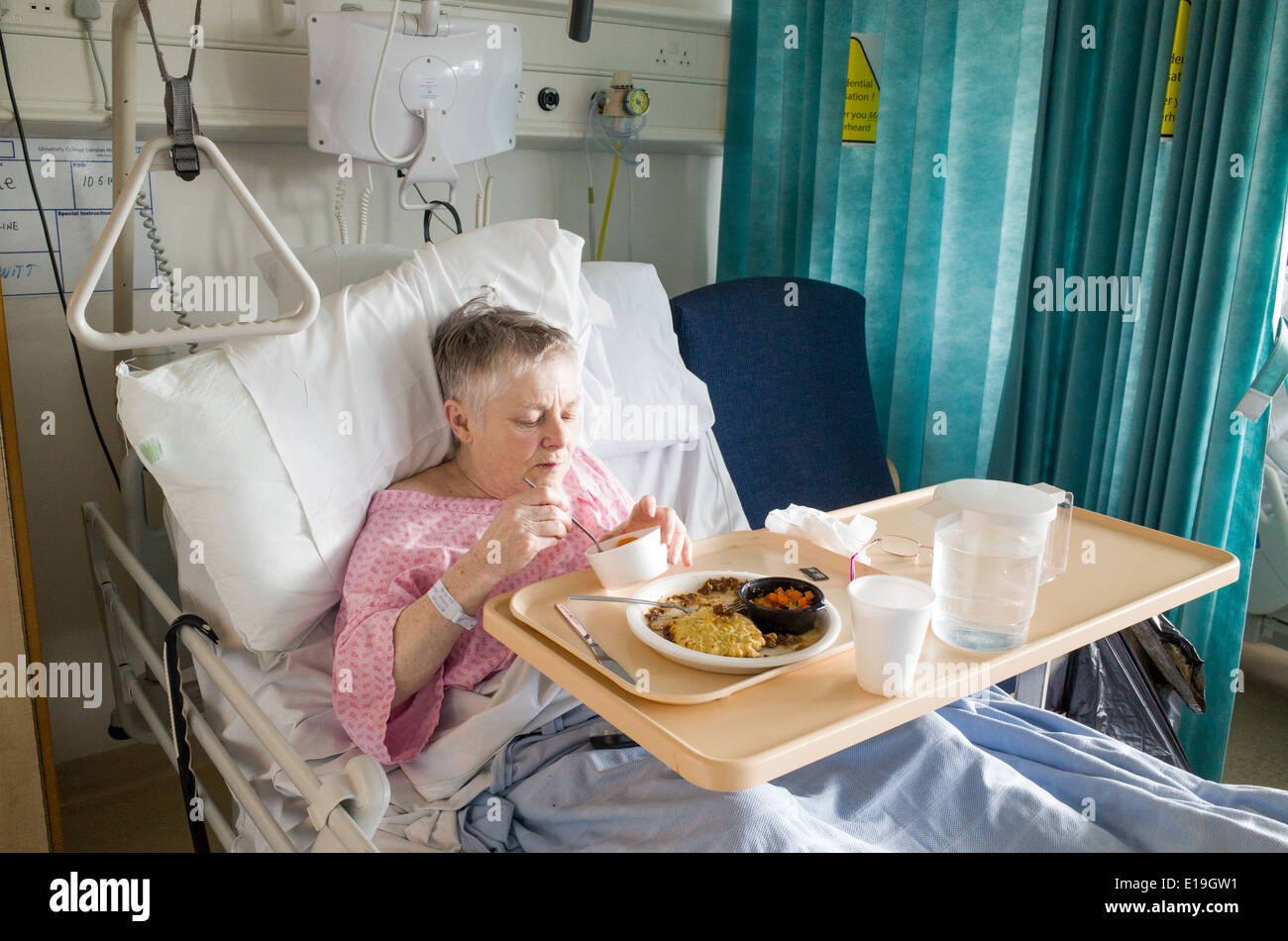 Paciente anciano, en el University College Hospital de comer la comida del hospital, Londres, Inglaterra, Reino Unido. Foto de stock