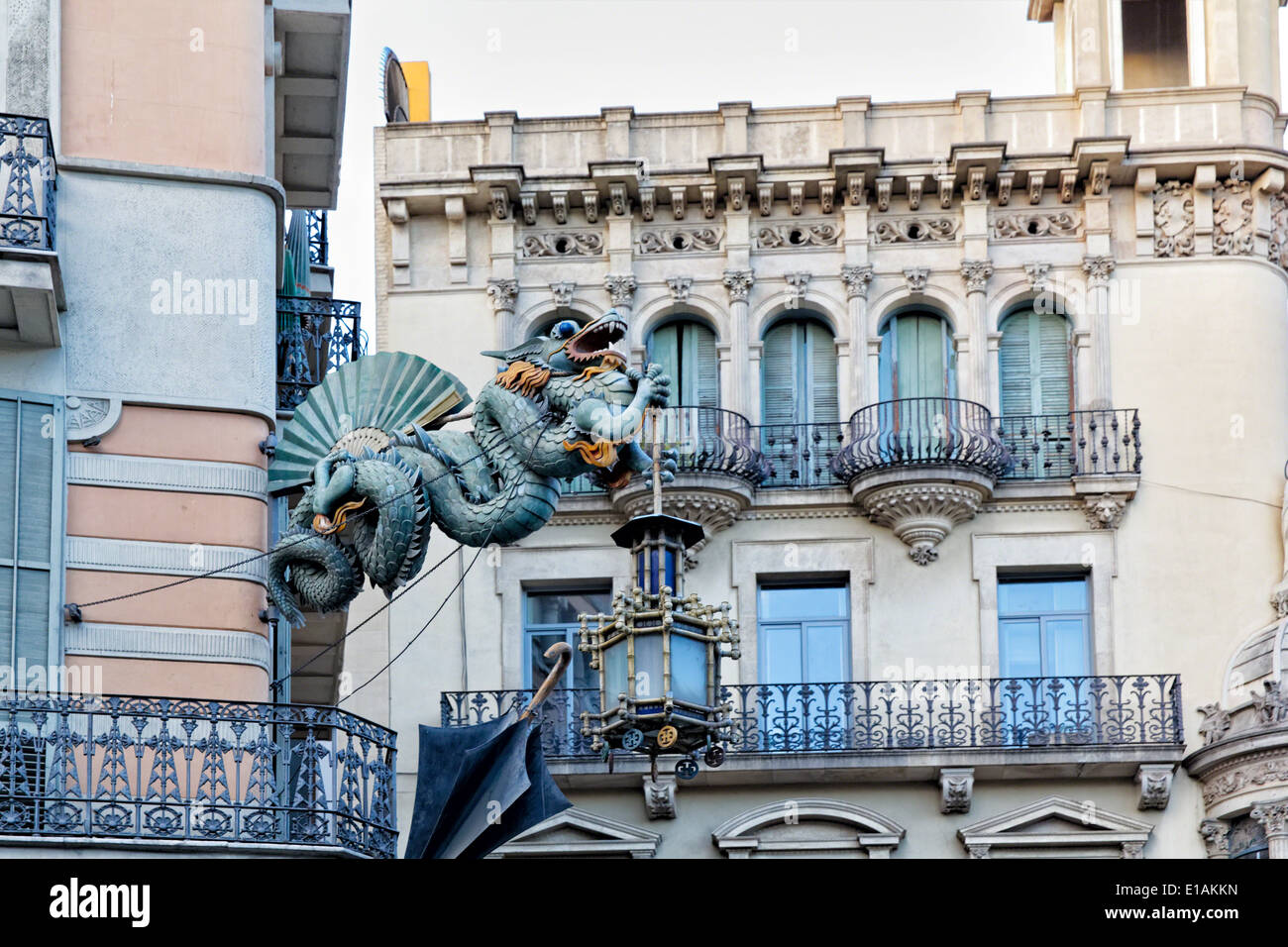 Dragón Chino escultura sobre las paredes de una casa decorada con sombrillas, Bruno Quadras Edificio, Las Ramblas, Barcelona Foto de stock