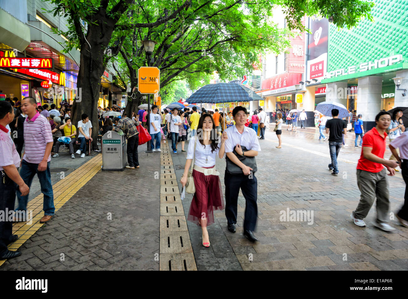 Consumismo chino: los compradores jóvenes pasee por una importante calle comercial de una gran ciudad en la China moderna. Beijing Lu (Beijing, Guangzhou Road). Foto de stock