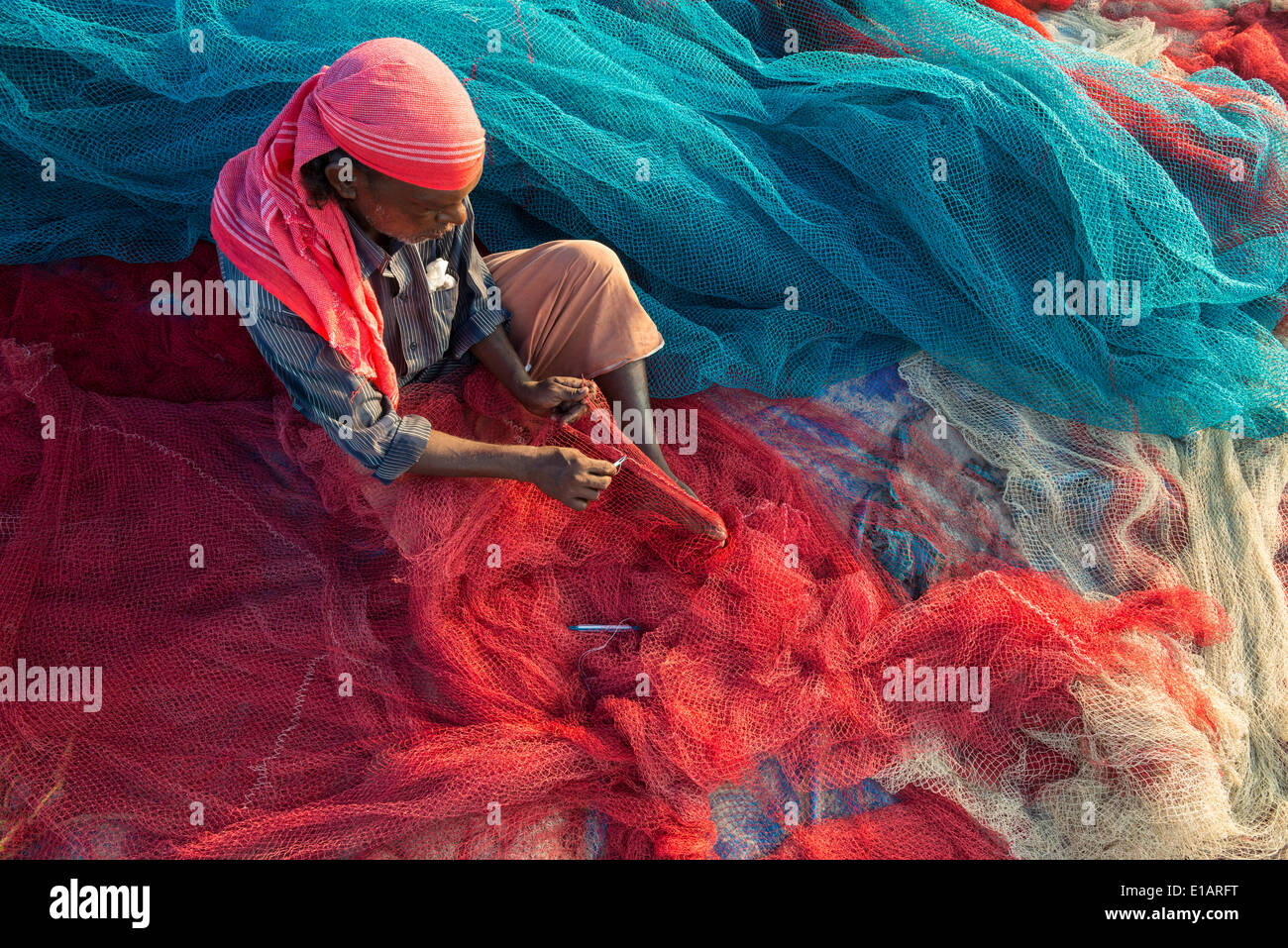 Pescador reparación de redes de pesca, Varkala, Kerala, India Foto de stock